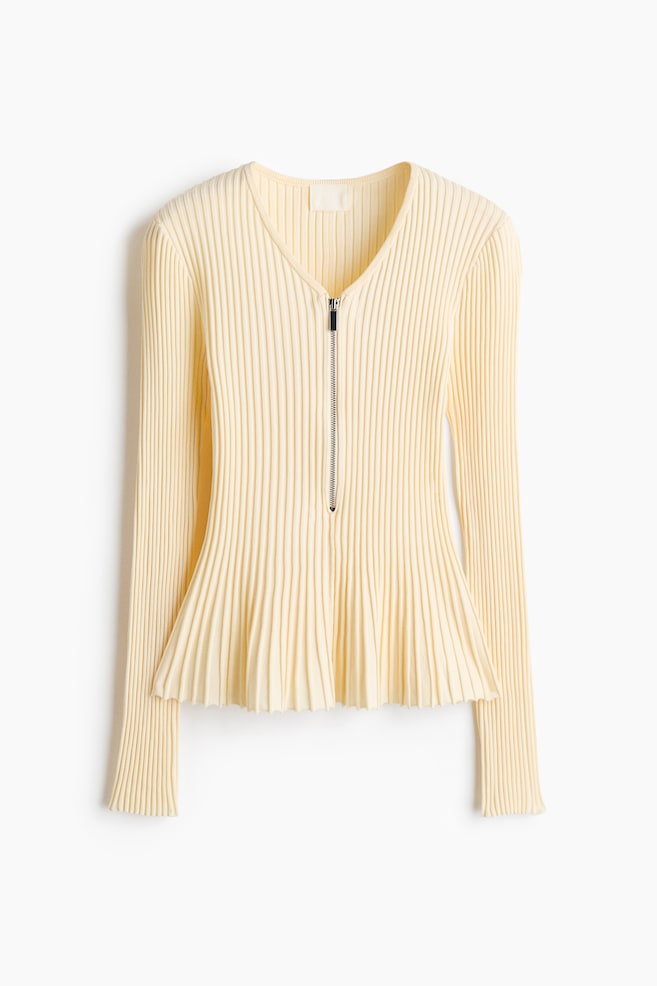 Un top tricotat cu texturÄ ribatÄ, de culoare galben deschis, este prezentat din faÈÄ, evidenÈiind un decolteu în V cu închidere half-zip în nuanÈÄ argintie. Piesa cu mâneci lungi se strâmteazÄ Ã®n talie Èi se evazeazÄ Ã®ntr-un tiv peplum plisat. - 1