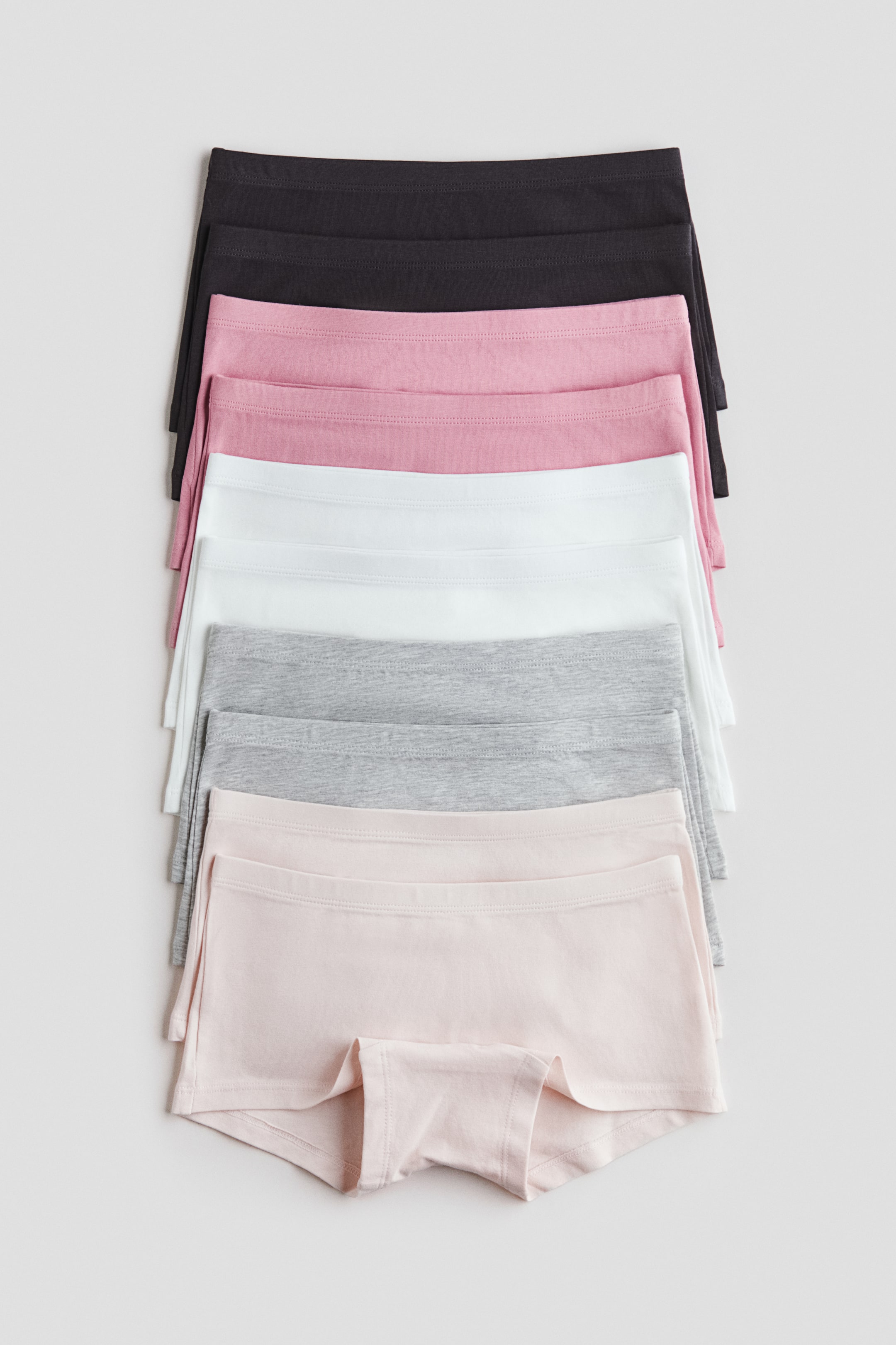 View larger image: "Soft jersey boxer briefs are on display, featuring an elastic waistband. Several pairs are neatly stacked, highlighting shades of black, pink, white, grey, and light pink, with the front of the bottom pair prominently visible."