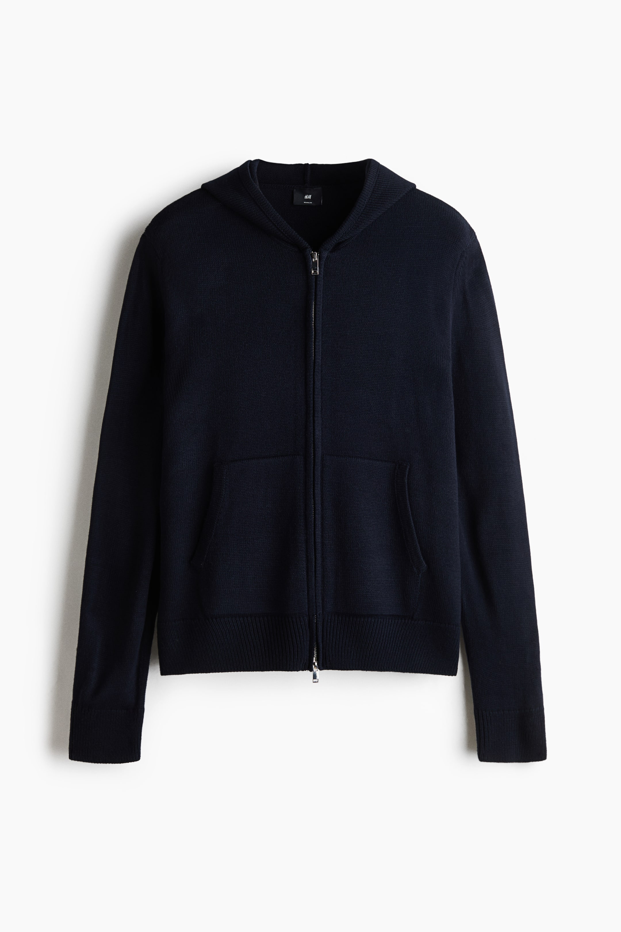 Agrandir l'image: Un cardigan à capuche en maille bleu marine foncé est présenté de face, avec une fermeture éclair frontale bidirectionnelle argentée et deux poches plaquées sur le devant. Le modèle est complété par des manches longues avec poignets côtelés et un ourlet côtelé assorti.