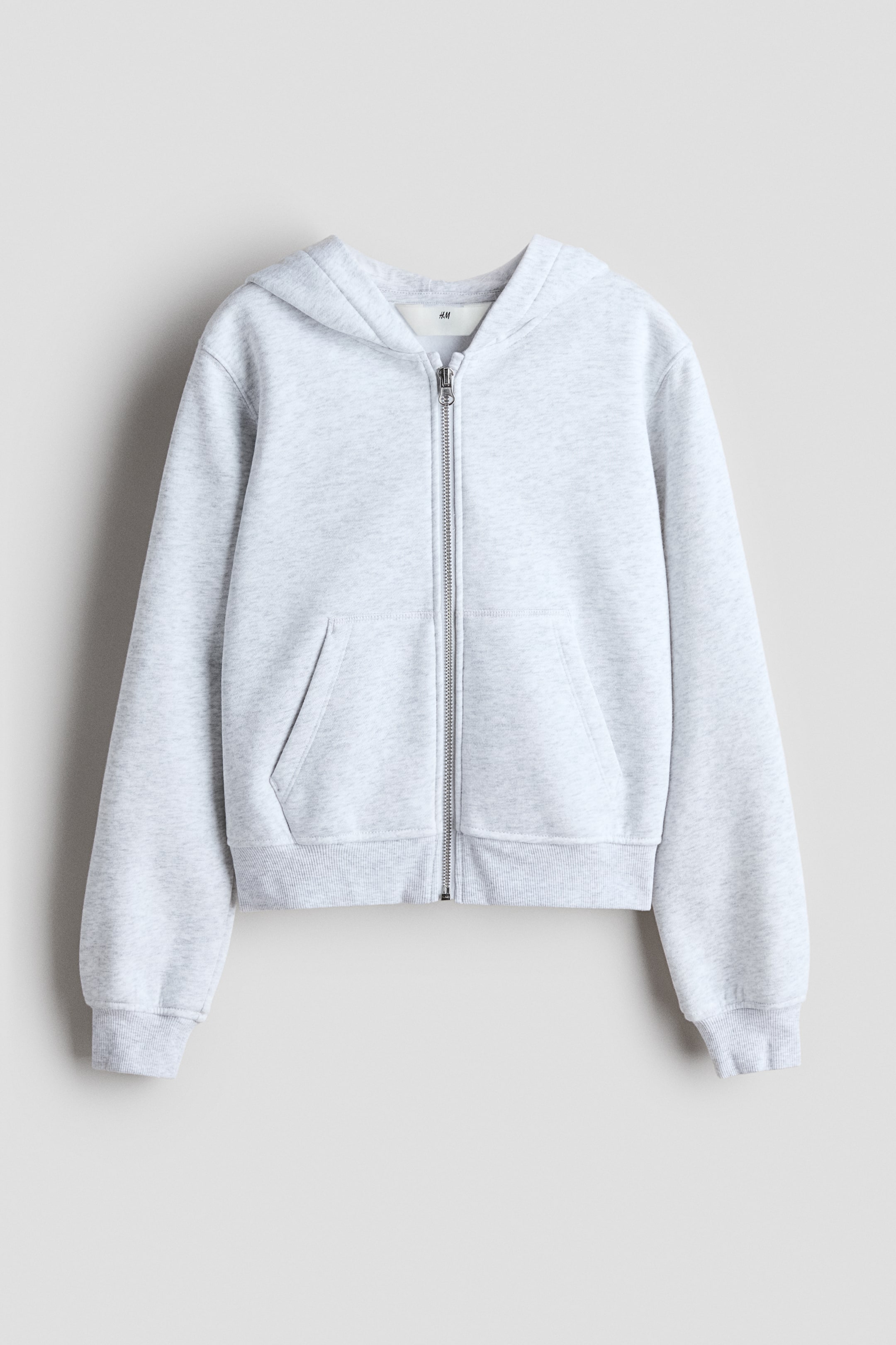 View larger image: A light grey sweatshirt fabric zip-through hoodie is facing FRONT, featuring a full zip-down front. It is displaying a hood, two front pockets, ribbed cuffs, and a ribbed hem.