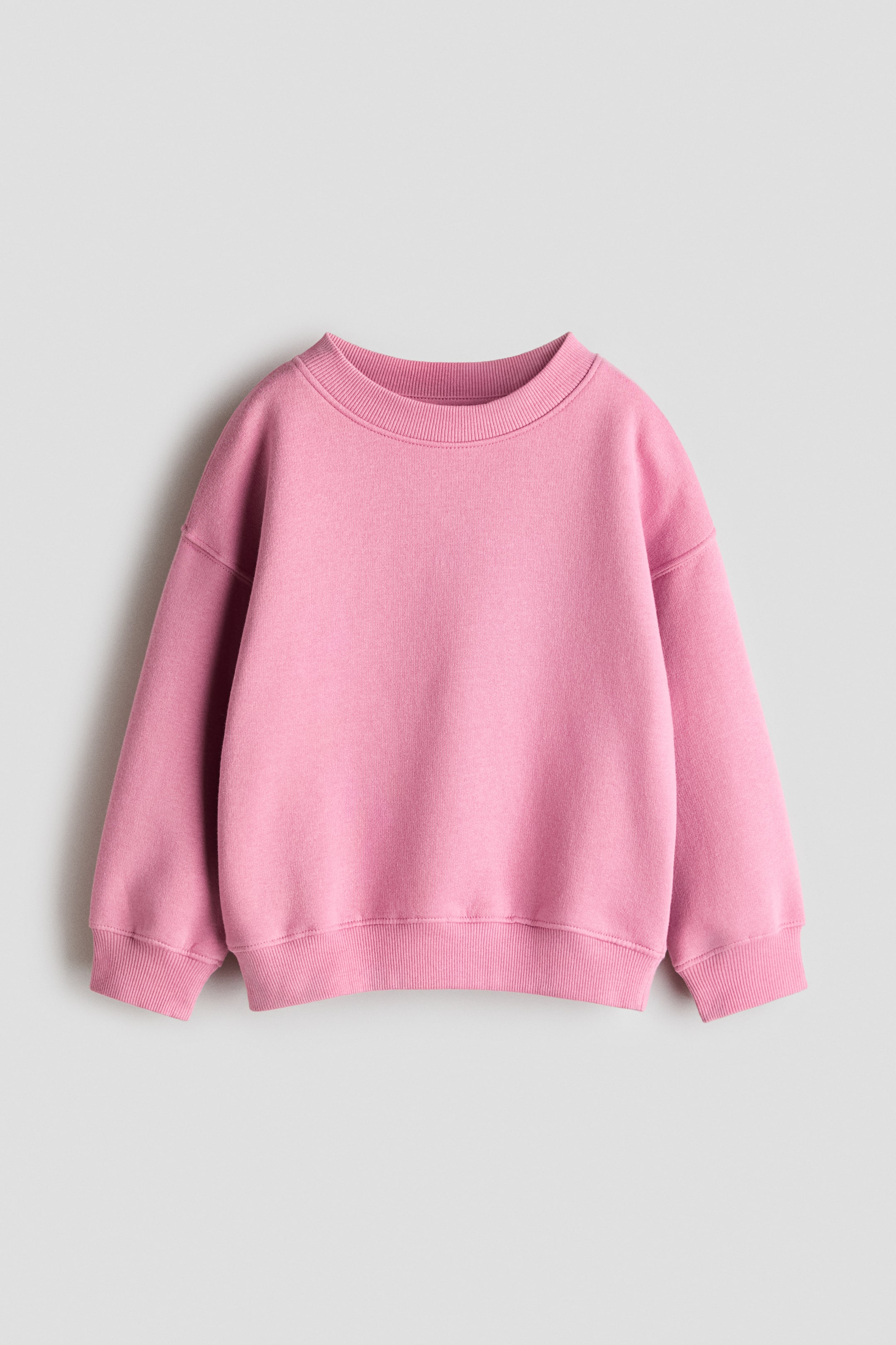 View larger image: A pink sweatshirt featuring a crew neck, ribbed cuffs, and a ribbed hem.