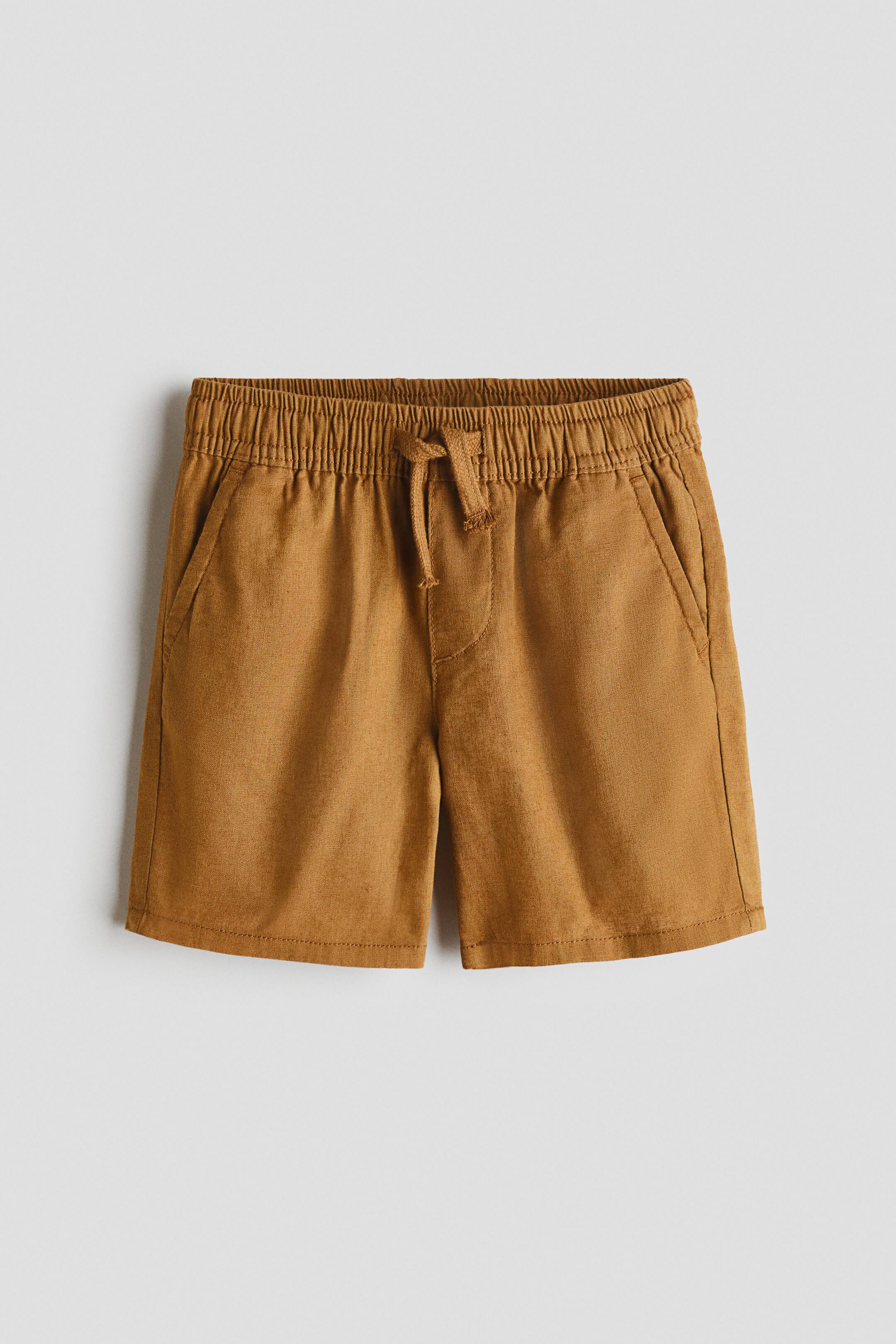 View larger image: Brown shorts are showcased from the front, highlighting an elastic waistband with a tied drawstring and two slanted side pockets.