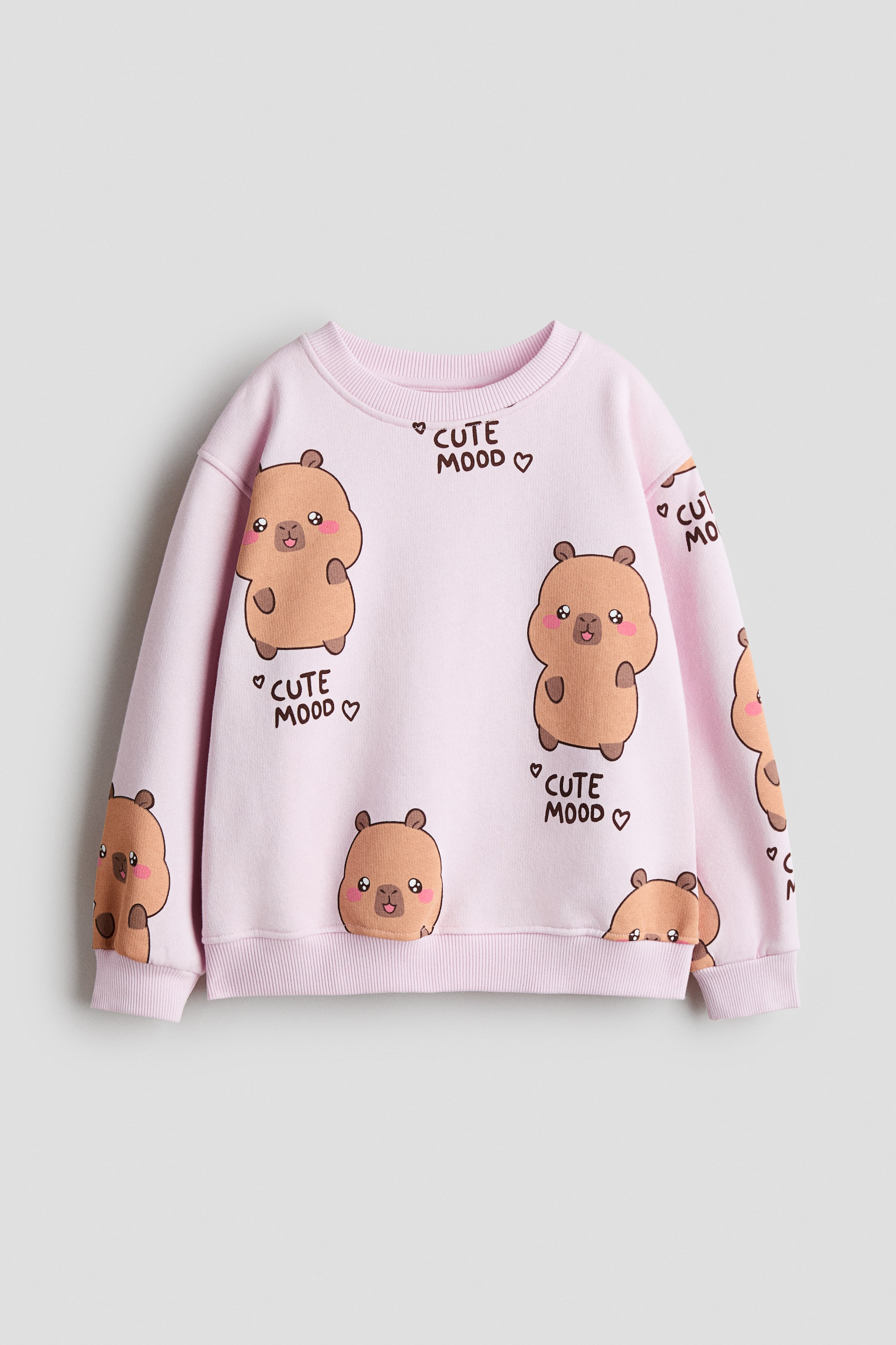 Agrandir l'image: Un sweat-shirt rose arbore un motif répétitif d'ours bruns dessinés avec des joues roses et le texte "CUTE MOOD ?" sur le DEVANT. Il présente un col rond côtelé, des épaules tombantes, des manches longues, ainsi que des poignets et un ourlet côtelés.