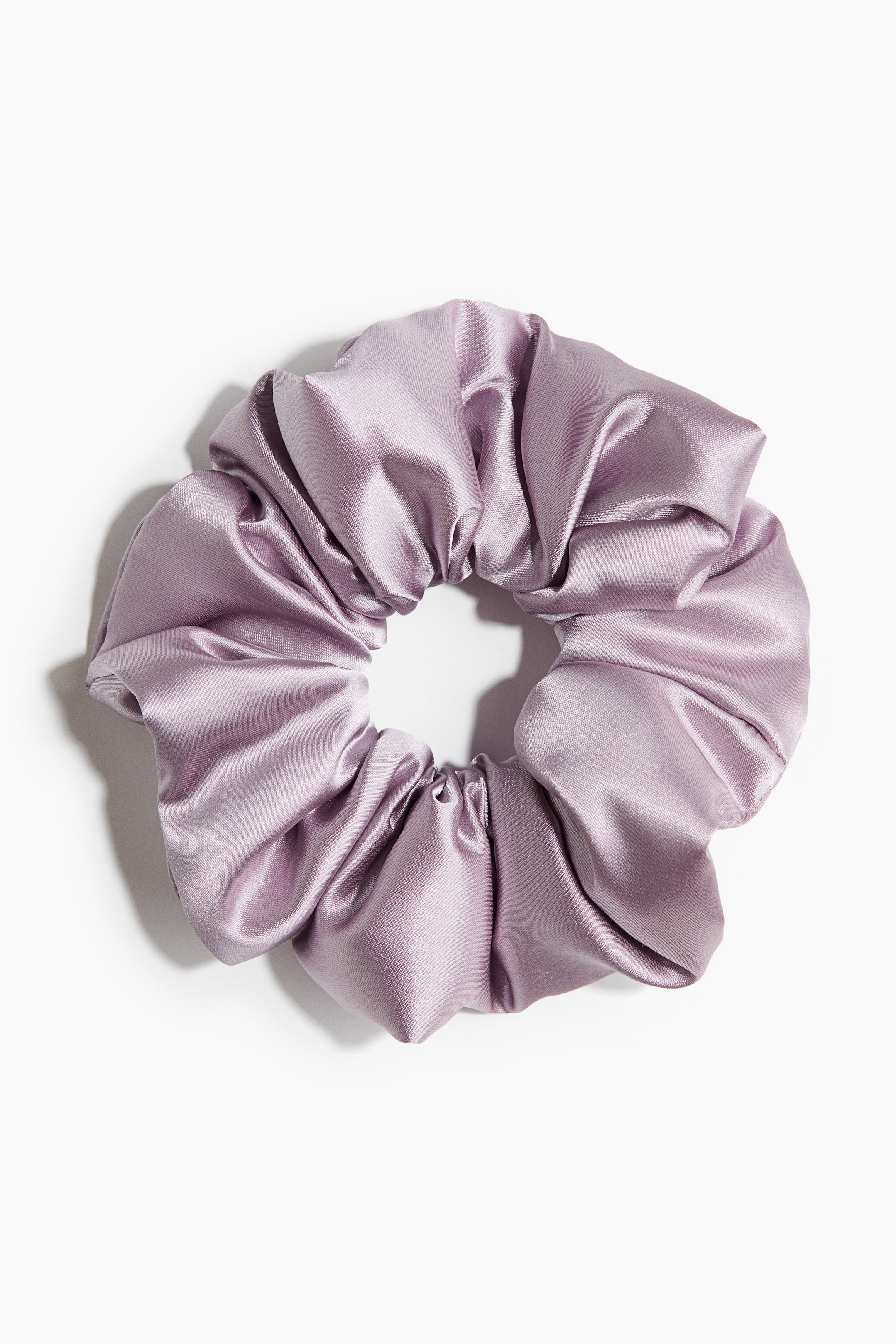 Ver imagem maior: Um grande elástico de cabelo em cetim lilás lustroso forma pregas volumosas, criando uma forma circular e franzida quando colocado plano.