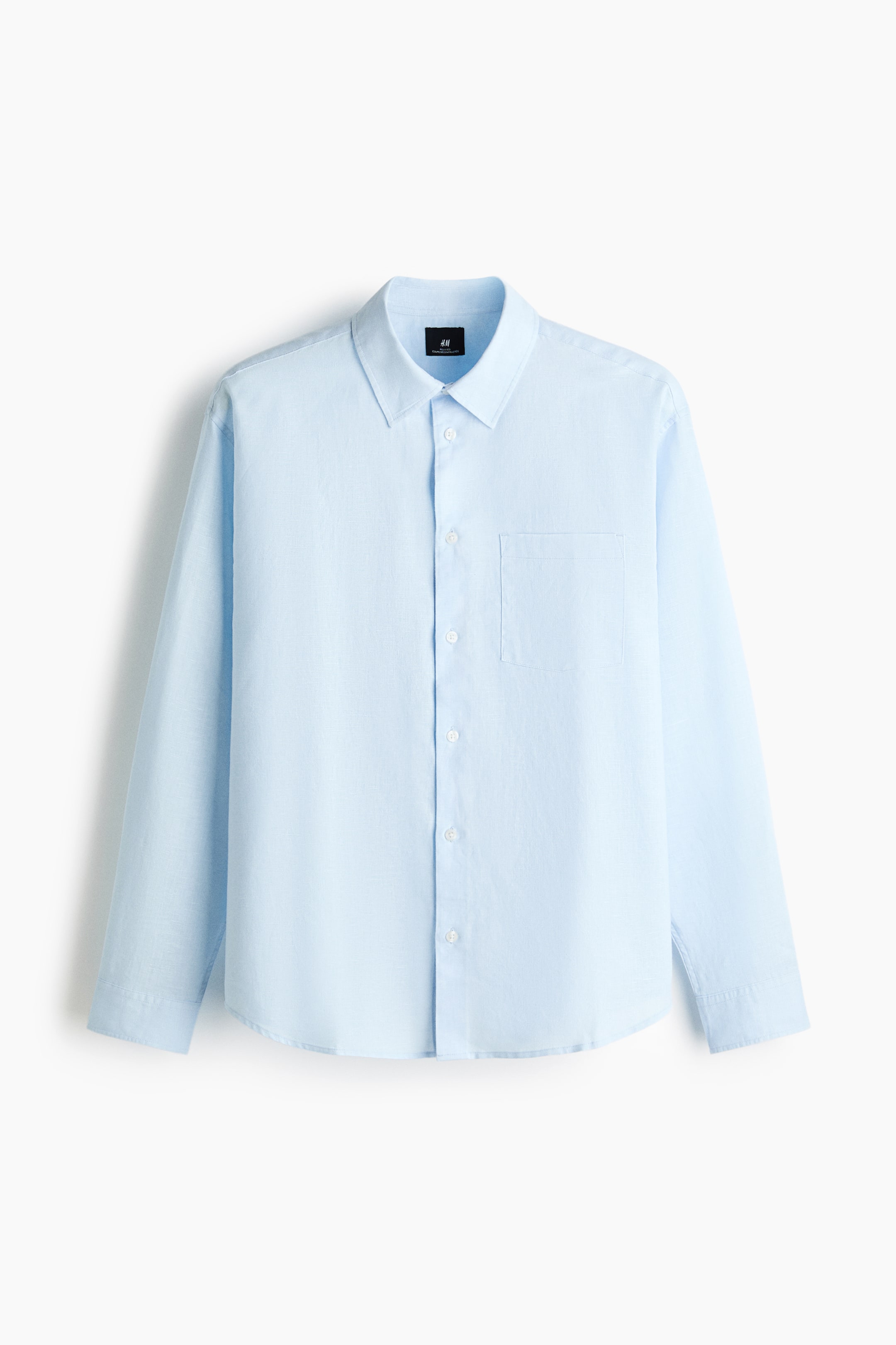 View larger image: A light blue long-sleeved shirt is facing FRONT, displaying a pointed collar, a full-button placket with white buttons, a patch pocket on the left chest, long sleeves with single-button cuffs, and a curved hem. (Note: The content is already in English and adheres to Canadian English conventions such as spelling and grammar. No further changes are necessary.)