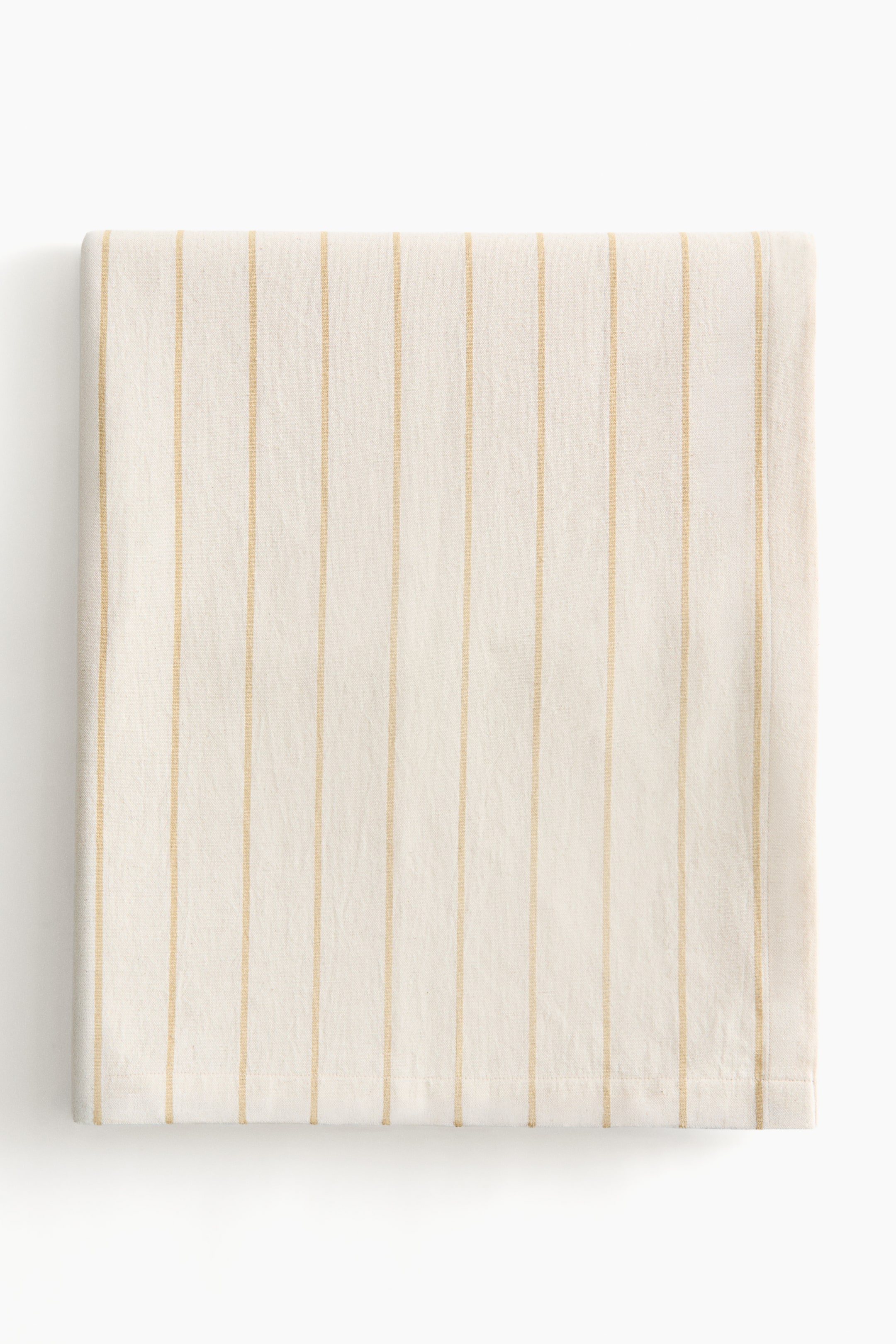 View larger image: The tablecloth showcases its front, folded horizontally, crafted from an off-white fabric adorned with vertical beige yarn-dyed stripes, and completed with a visible folded hem along the bottom edge.