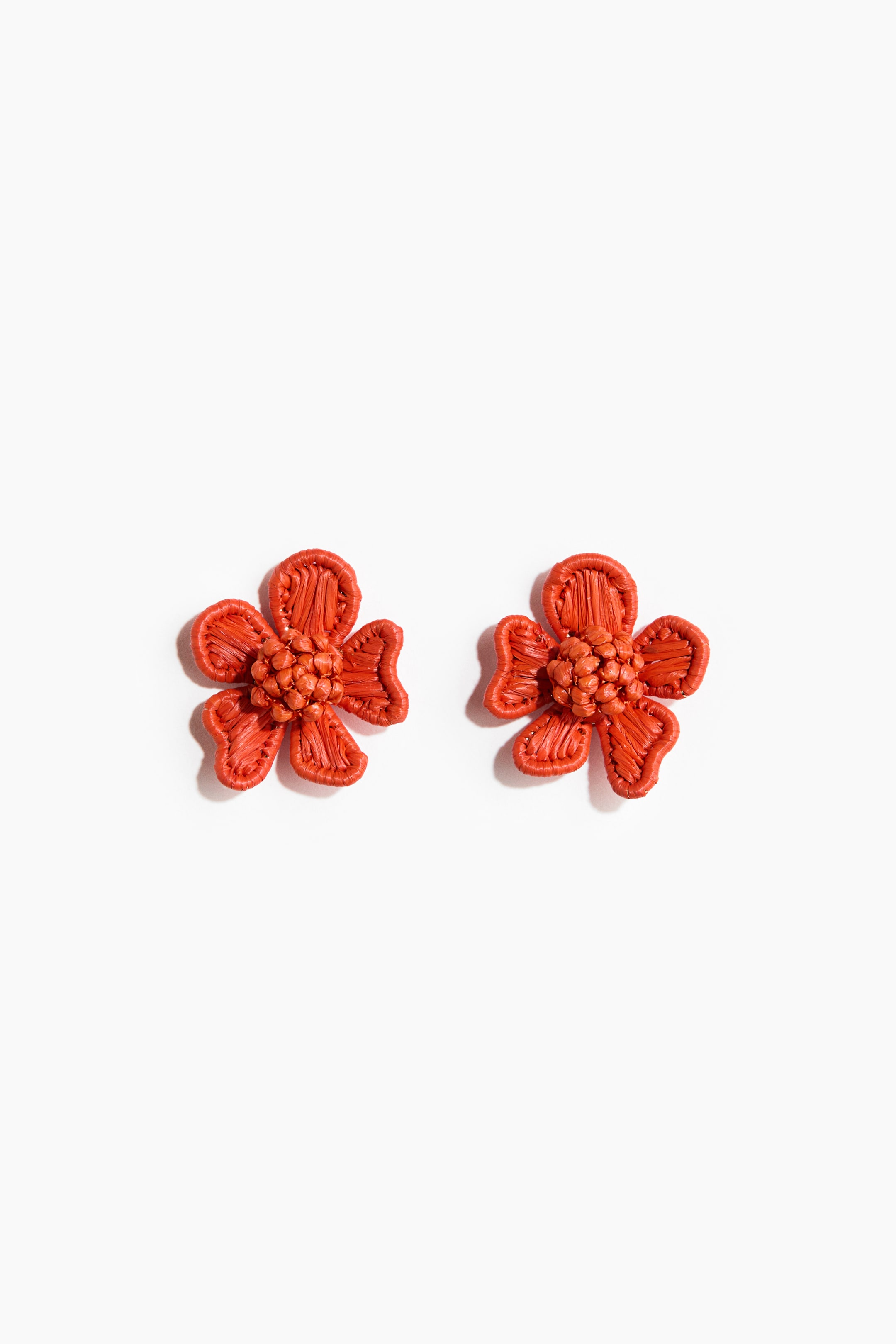 Ver imagen más grande: El par de pendientes presenta una vista frontal de dos diseños en forma de flor naranja. Cada flor cuenta con cinco pétalos trenzados que rodean un grupo central de pequeños elementos redondos tejidos.