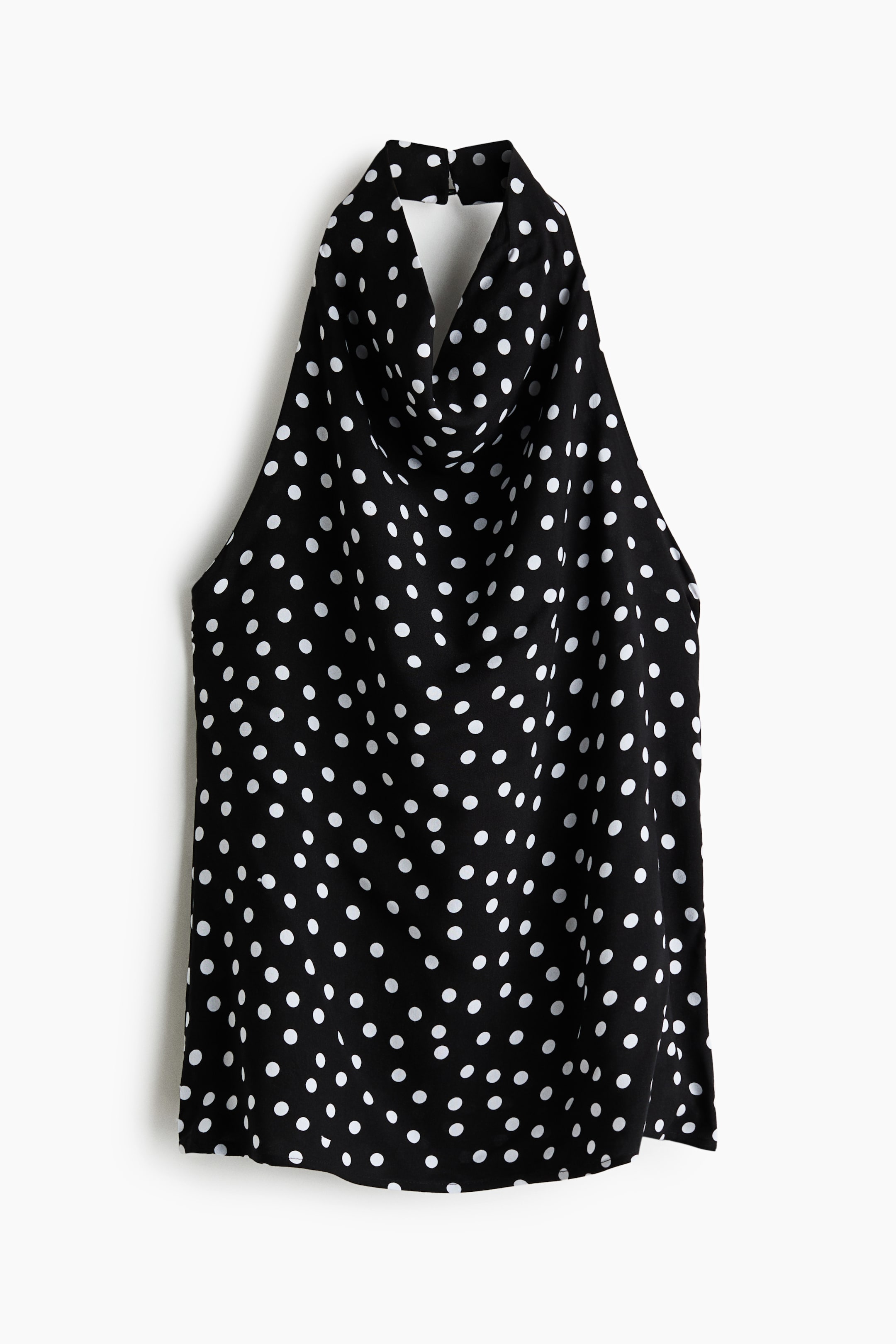 View larger image: A black halter-neck top in a viscose weave with white polka dots features a cowl neckline and a wide halter strap. The strap secures at the back of the neck with a hook-and-eye fastening, and the front of the top showcases its flowing design with an open back.