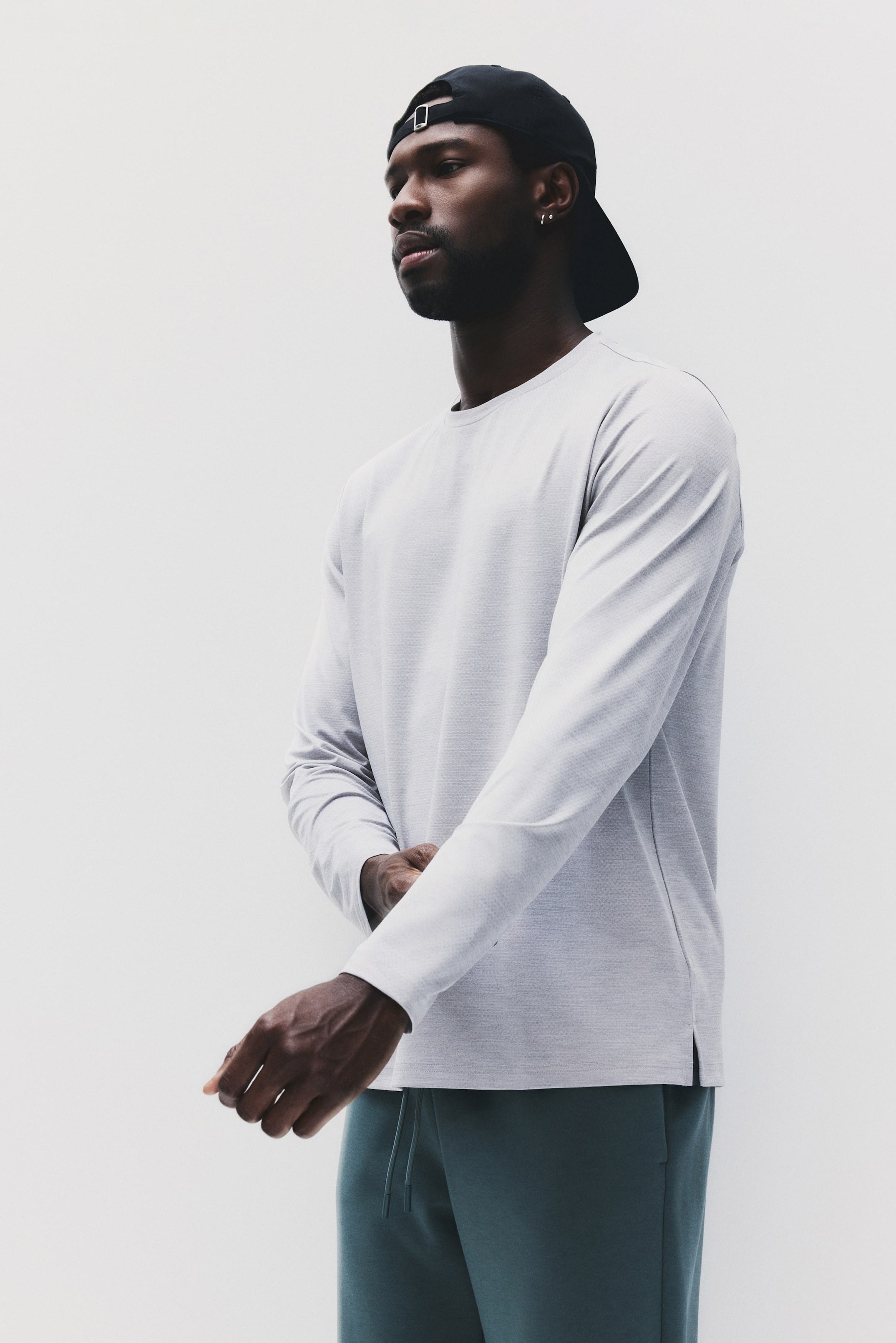 הצגת תמונה גדולה יותר: חולצת צווארון עגול עם שרוולים ארוכים בצבע אפור בהיר, מתאפיינת בבד מרקם עדין ושוליים ישרים עם חריצים קטנים בצדדים. היא מציגה גזרה רגילה מזווית קלה.