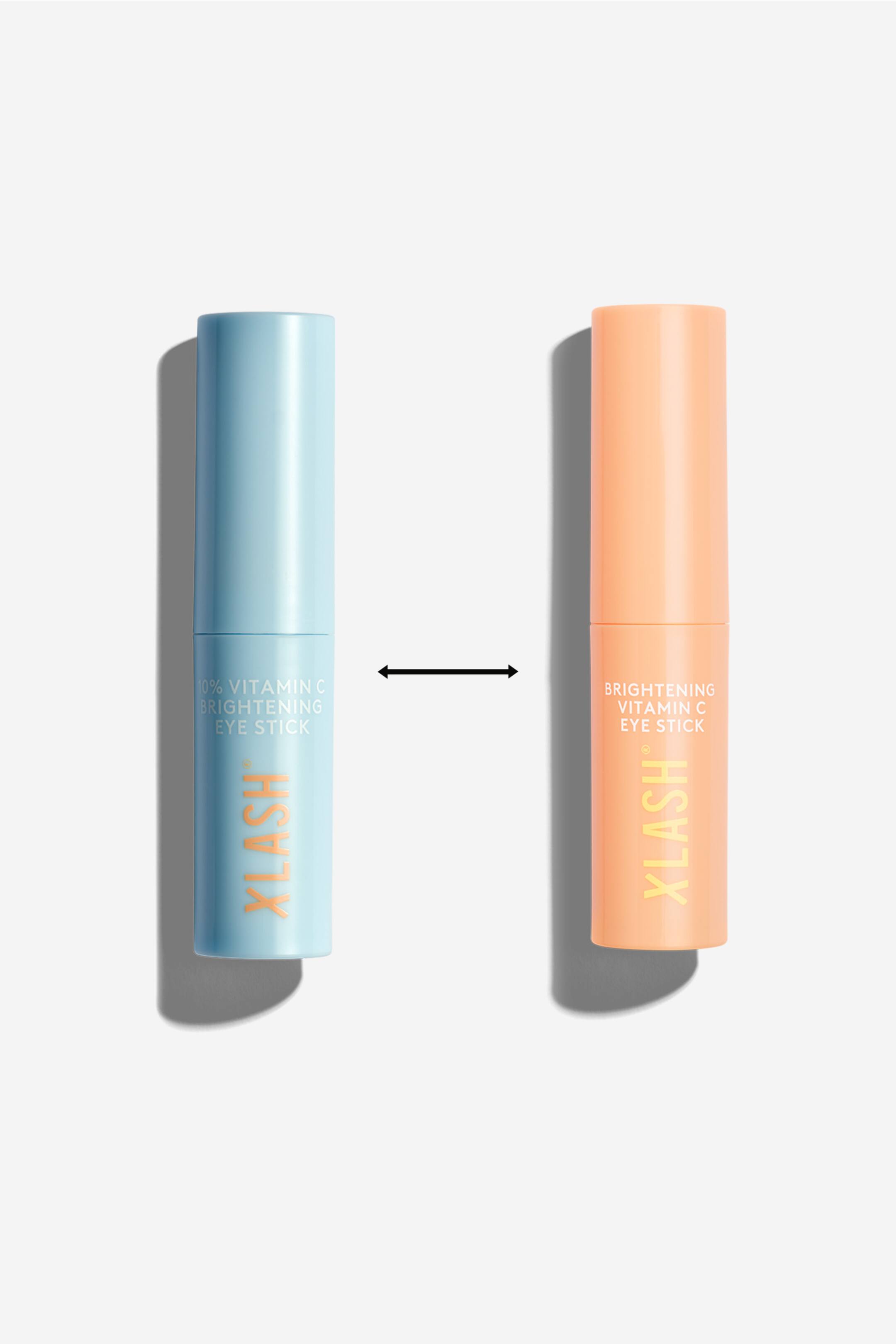 Vis større bilde: To sylinderformede øyepinner står oppreist og vender fremover. En pinne, i lys blå, har teksten "10% VITAMIN C BRIGHTENING EYE STICK" i hvit tekst og "XLASH" vertikalt i oransje, mens den andre, i lys fersken, viser "BRIGHTENING VITAMIN C EYE STICK" i hvit tekst og "XLASH" vertikalt i oransje.