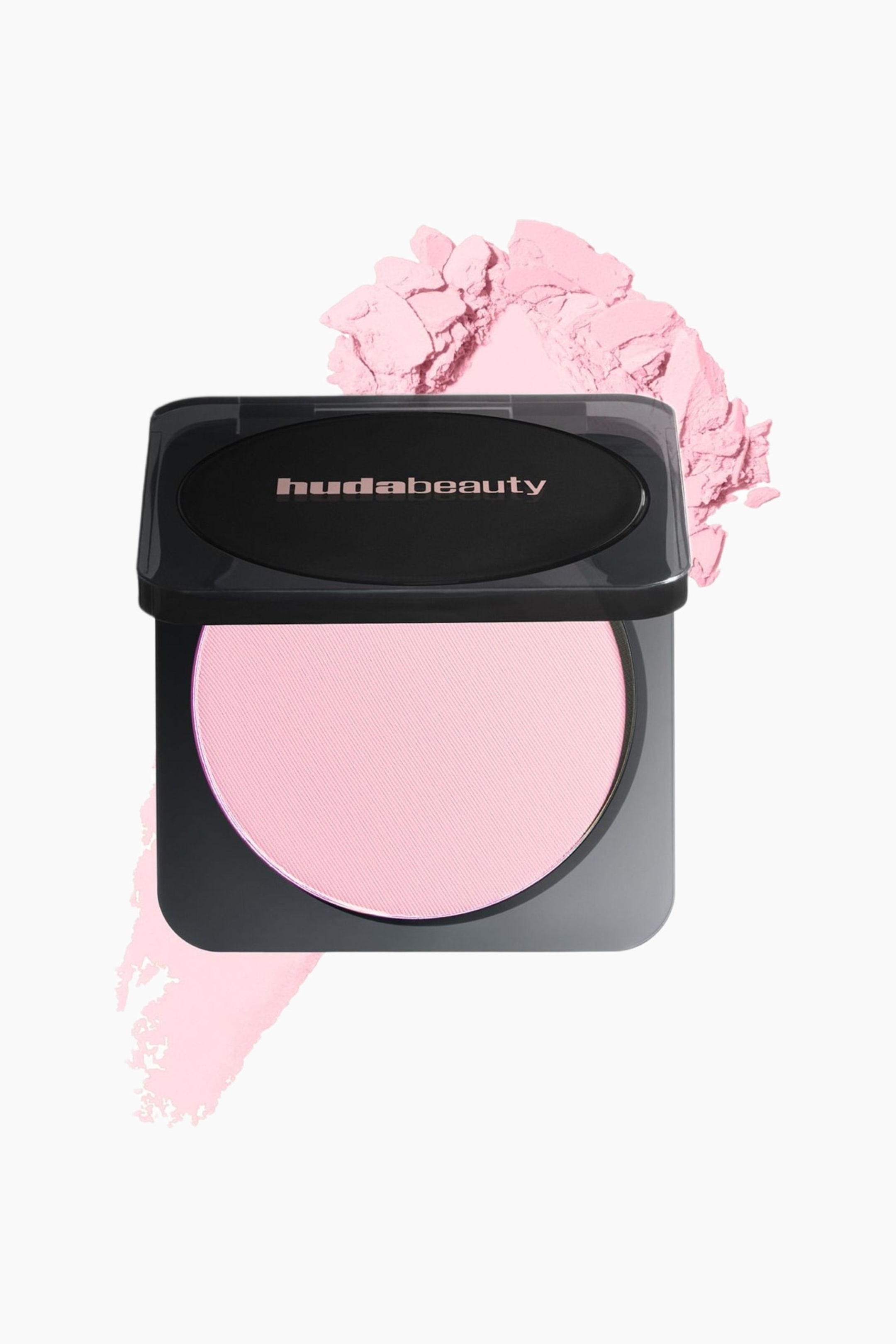 Visa större bild: Huda Beauty Easy Bake Pressed Powder-kompakten står öppen och visar en rund panna med ljusrosa pressat puder med fin diagonal struktur. Det upphöjda locket har "hudabeauty"-logotypen, medan ett texturerat prov av det ljusrosa pudret syns bakom kompakten för att visa dess konsistens.