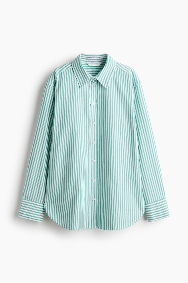 Uma camisa às riscas verdes e brancas apresenta uma gola, botões ao longo da frente, mangas compridas com punhos abotoados e uma bainha arredondada, exibindo um corte descontraído com ombros caídos. - 1