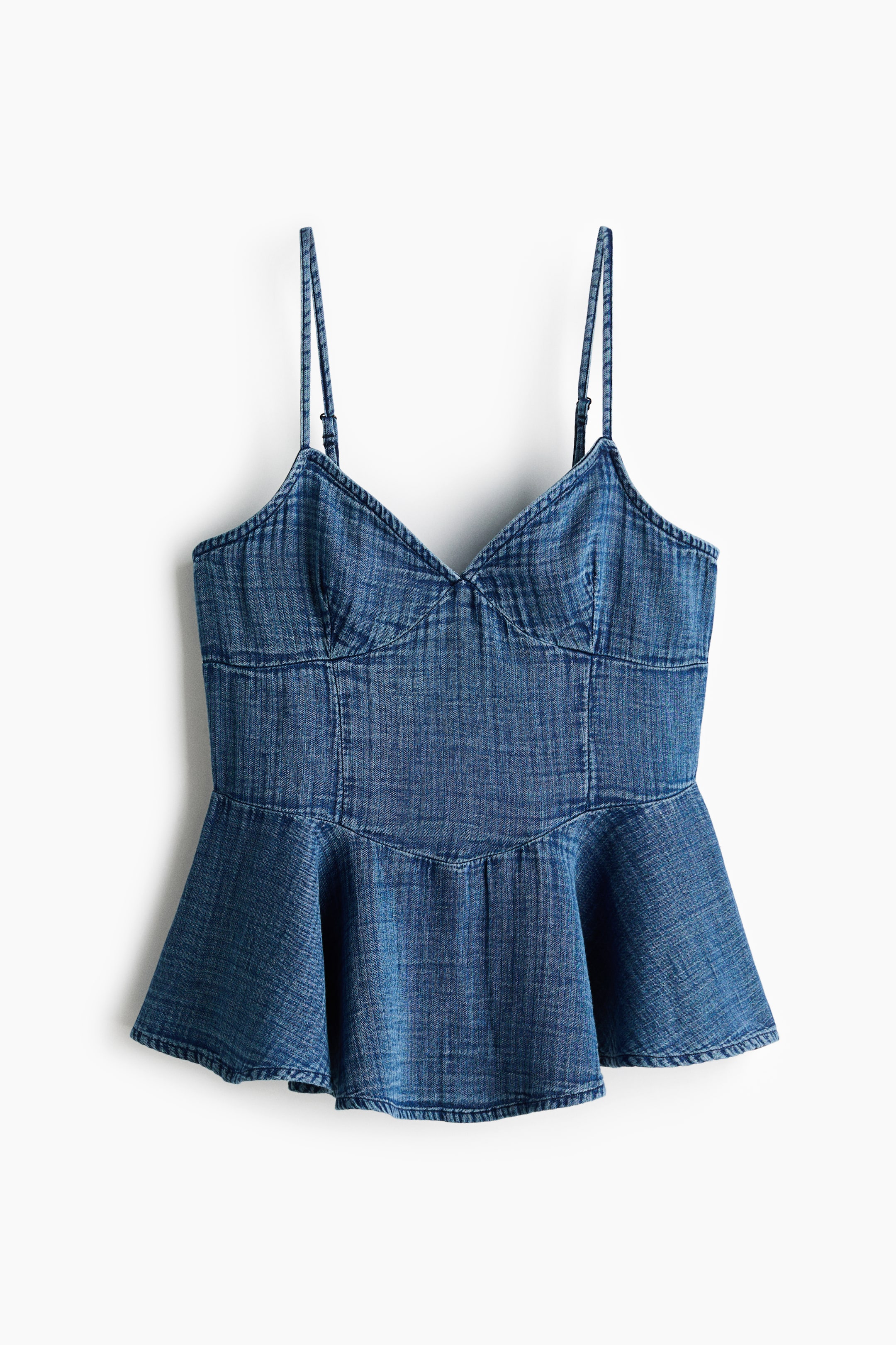 View larger image: Front-facing denim peplum top featuring a sweetheart neckline and adjustable spaghetti straps. The fitted bodice transitions into a flared peplum hem.