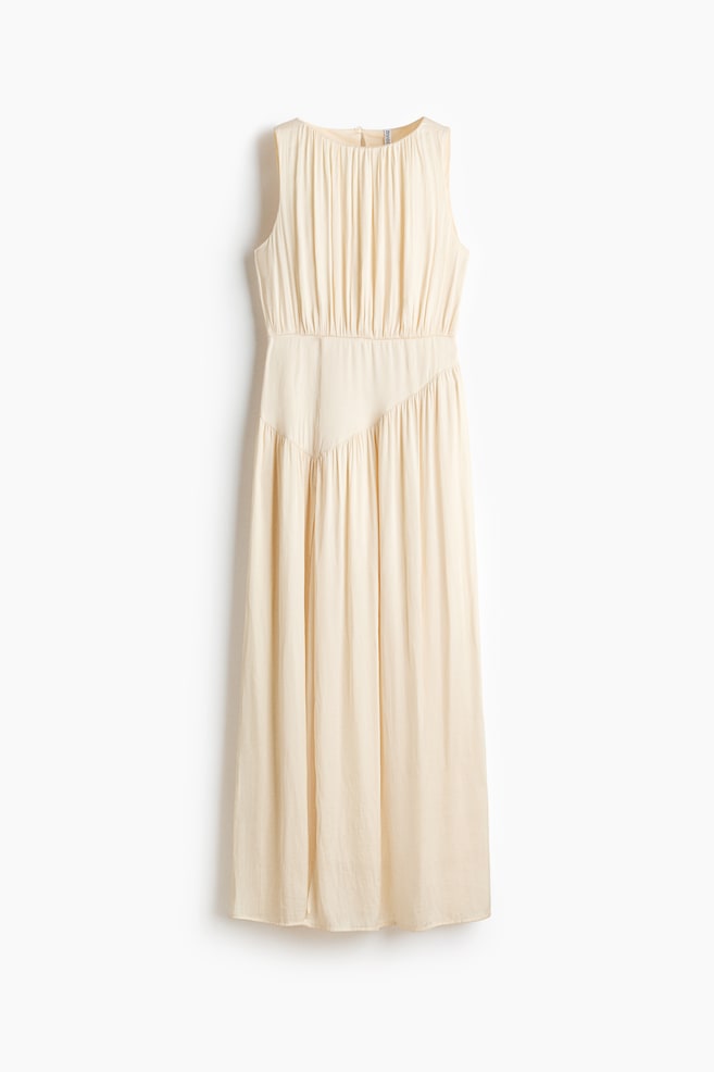 A calf-length, sleeveless dress in softly draping satin is shown from the front. It features a round, gathered neckline and a triangular section at the waist, with gathers creating a draped effect above and below this section. - 1