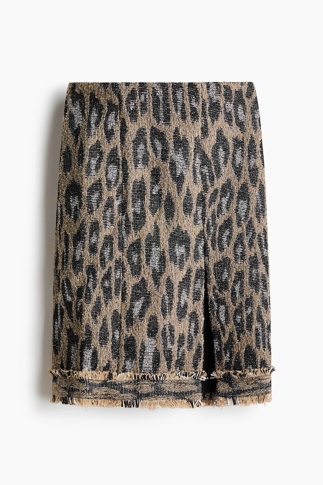 This front-facing skirt features a textured leopard print in brown, black and metallic silver tones. It has a straight silhouette with a subtle slit at the front left and a frayed, fringed hem. - 1