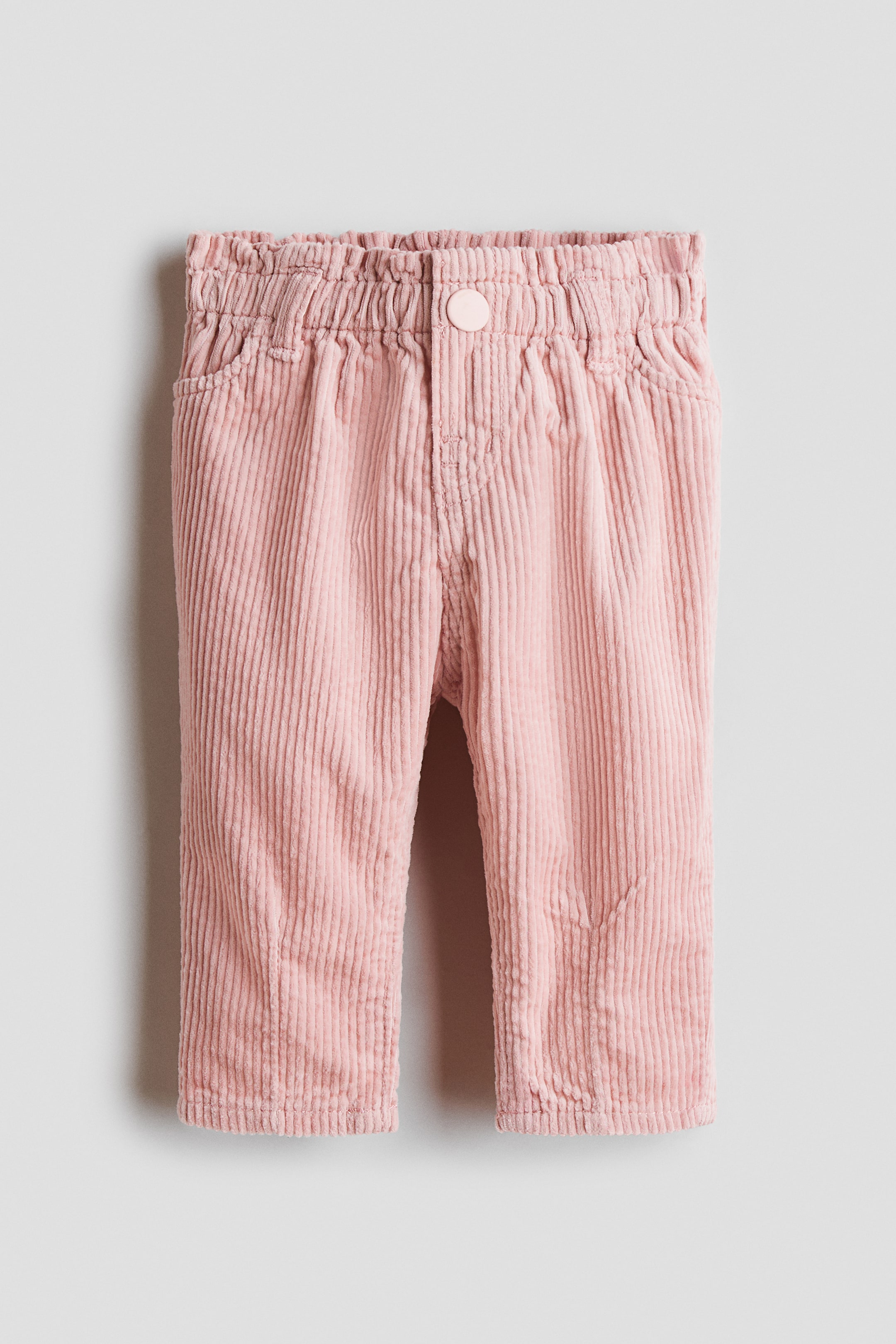 View larger image: Pink corduroy trousers feature an elasticated waistband with a single pink button and two side pockets, showcased from the front.