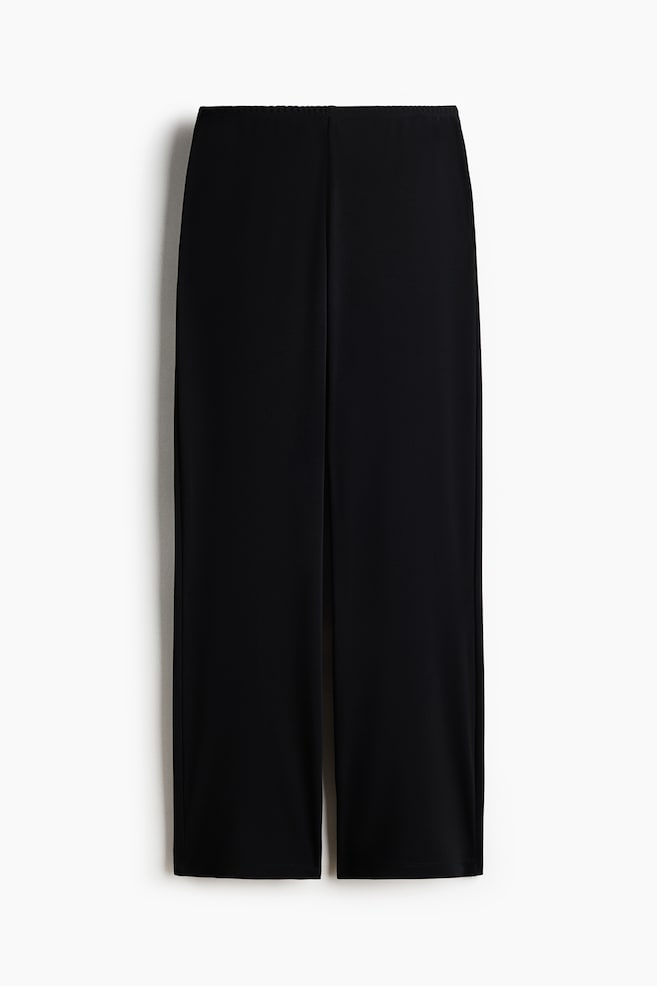 Pantaloni neri a gamba larga in tessuto liscio e scuro. Presentano un girovita elasticizzato e orli dritti. - 1