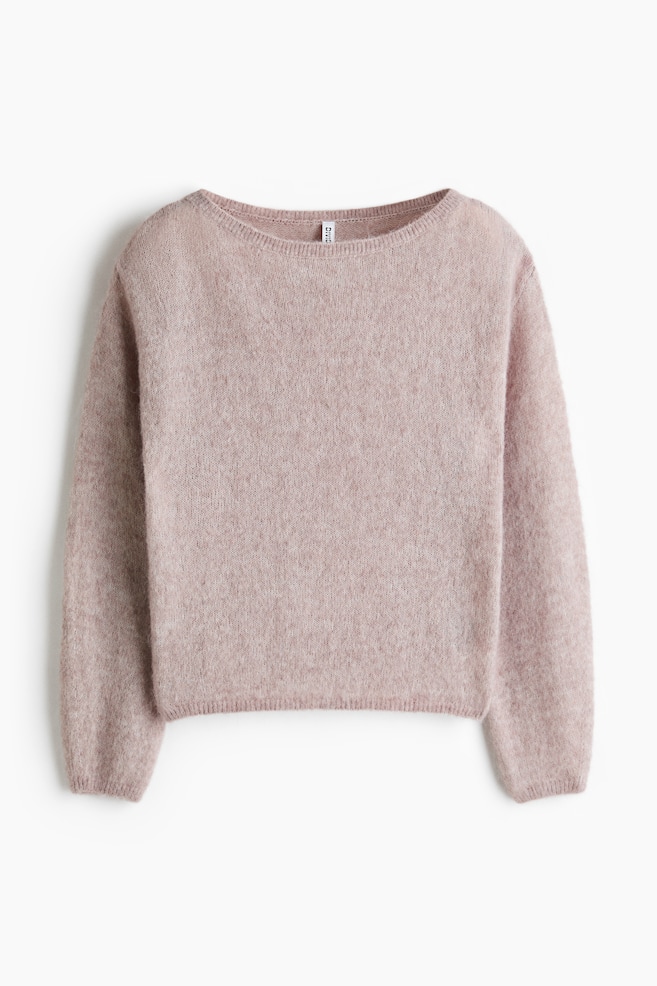 Un chandail rose pâle est présenté de face, mettant en valeur une texture tricotée duveteuse et un large col bateau. Il affiche des manches longues avec des poignets simples et un ourlet droit. Une petite étiquette blanche est visible à l'arrière du cou. - 1