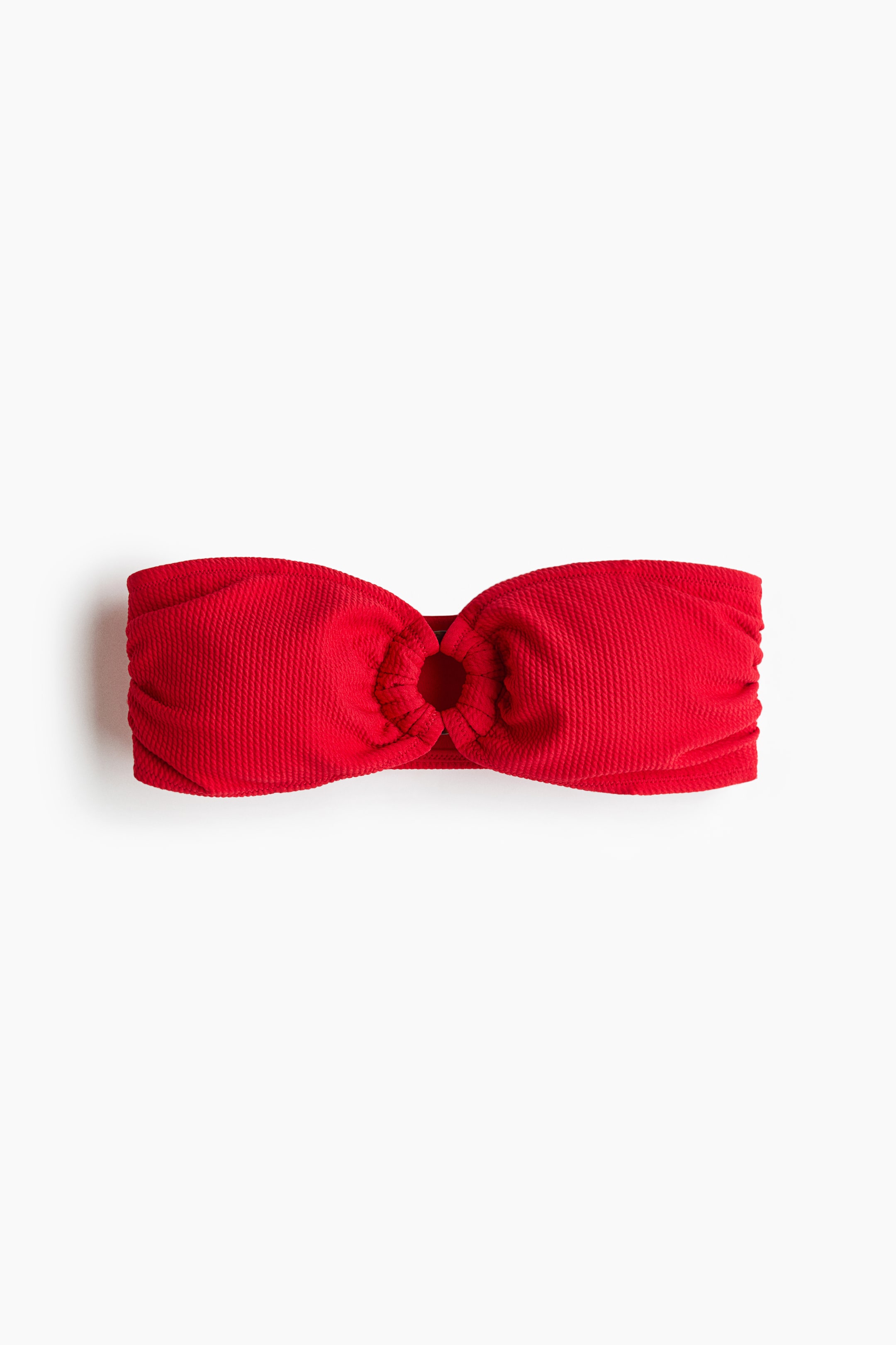 View larger image: "A red bandeau top is shown from the front, featuring a textured fabric and a central ring gathering the material."