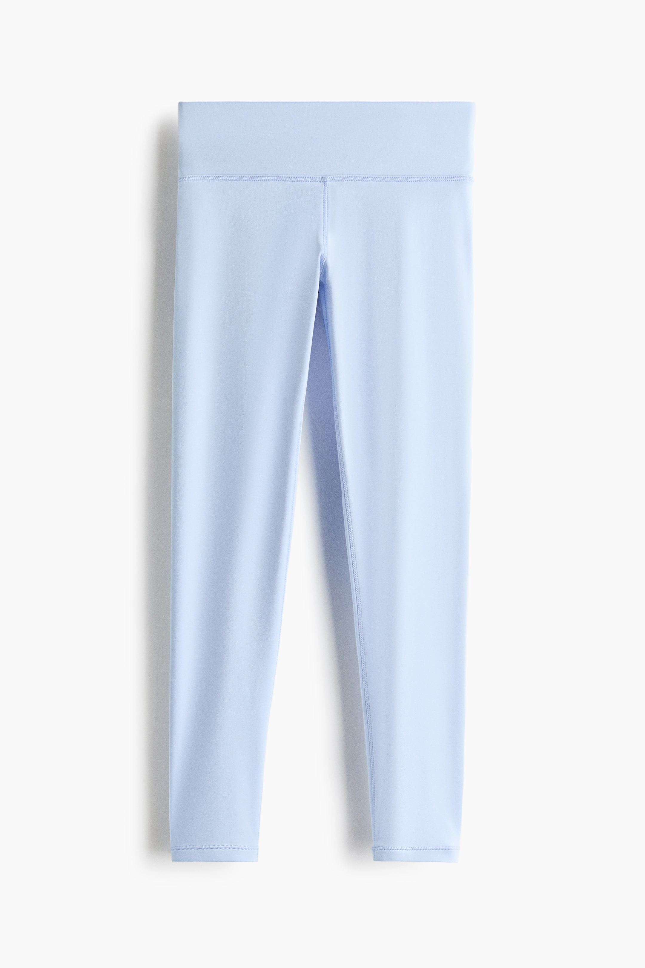 View larger image: Light blue sports leggings are shown in a front view, highlighting a broad waistband and noticeable flatlock seams. The leggings are displayed in a 7/8 length.