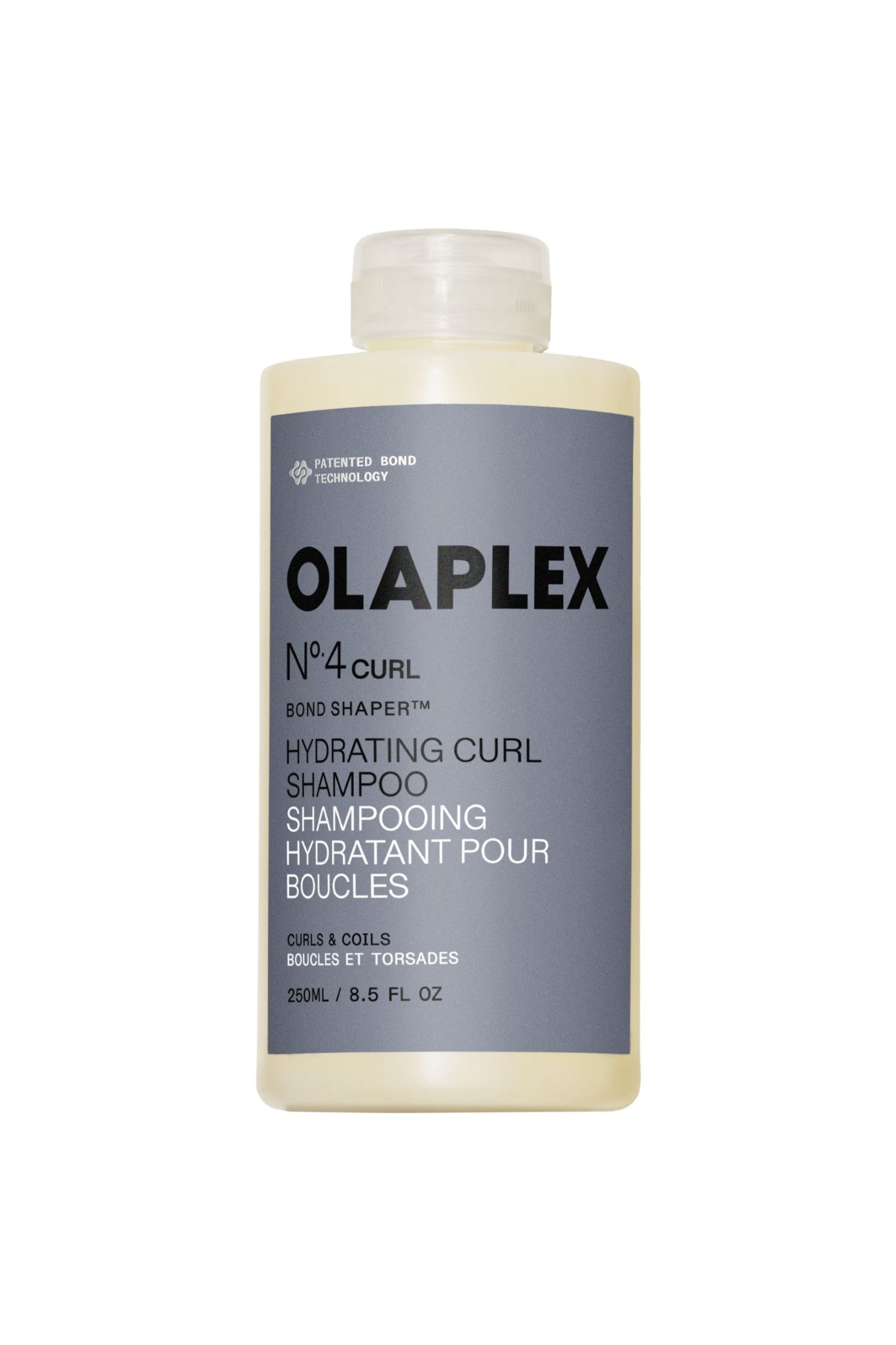 Visa större bild: En flaska Olaplex No.4C Bond Shaper Hydrating Curl Shampoo står upprätt, vänd framåt. Den har en blekgul genomskinlig kropp med ett klart flip-top lock, och dess gråa framsidesetikett visar 'OLAPLEX N�4 CURL HYDRATING CURL SHAMPOO' och '250ML / 8.5 FL OZ'.