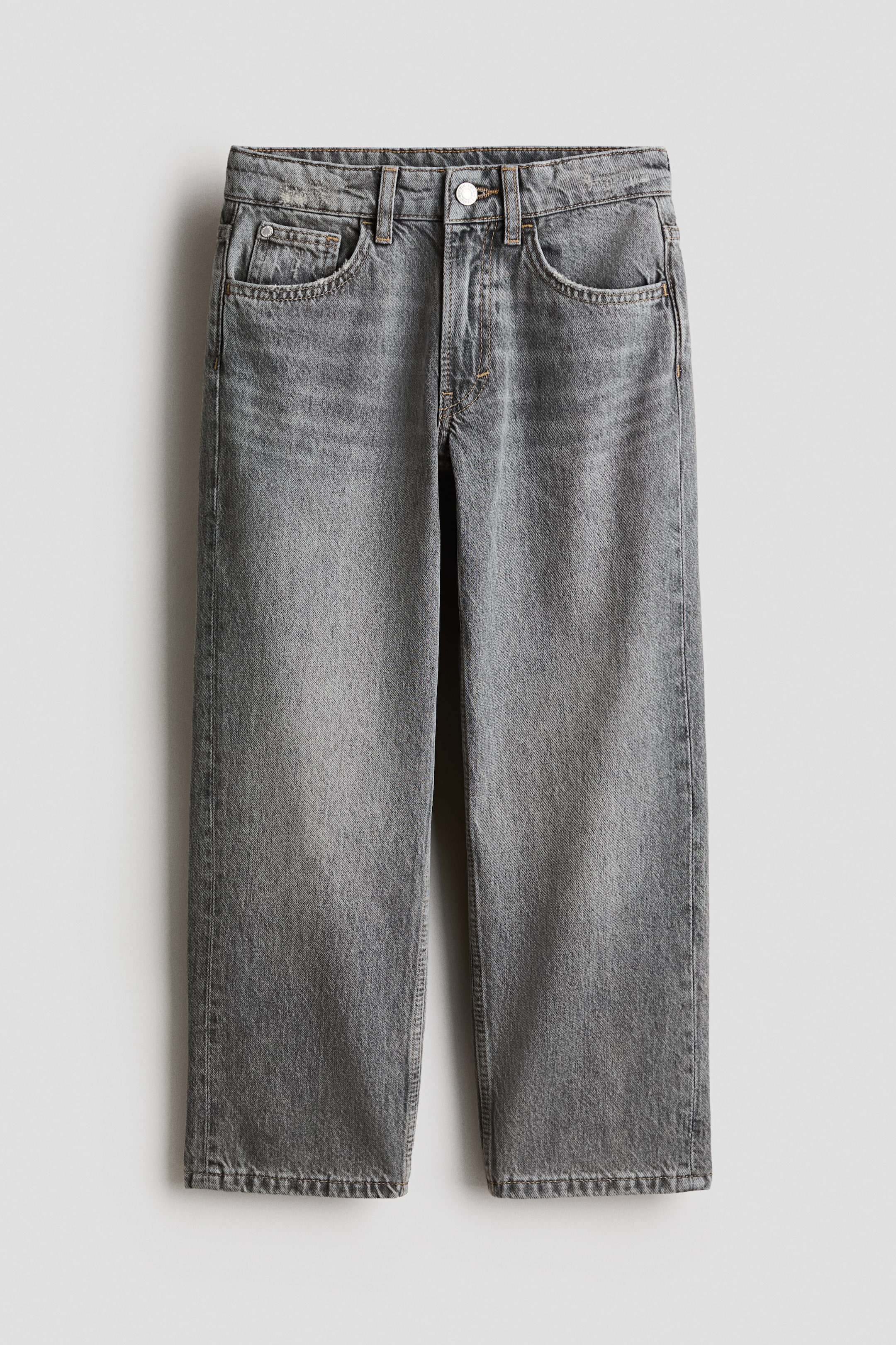 View larger image: The jeans are shown from the front, featuring a loose fit in washed grey cotton denim. They exhibit a 5-pocket design with a zip fly and button fastening at the waist, and straight legs.