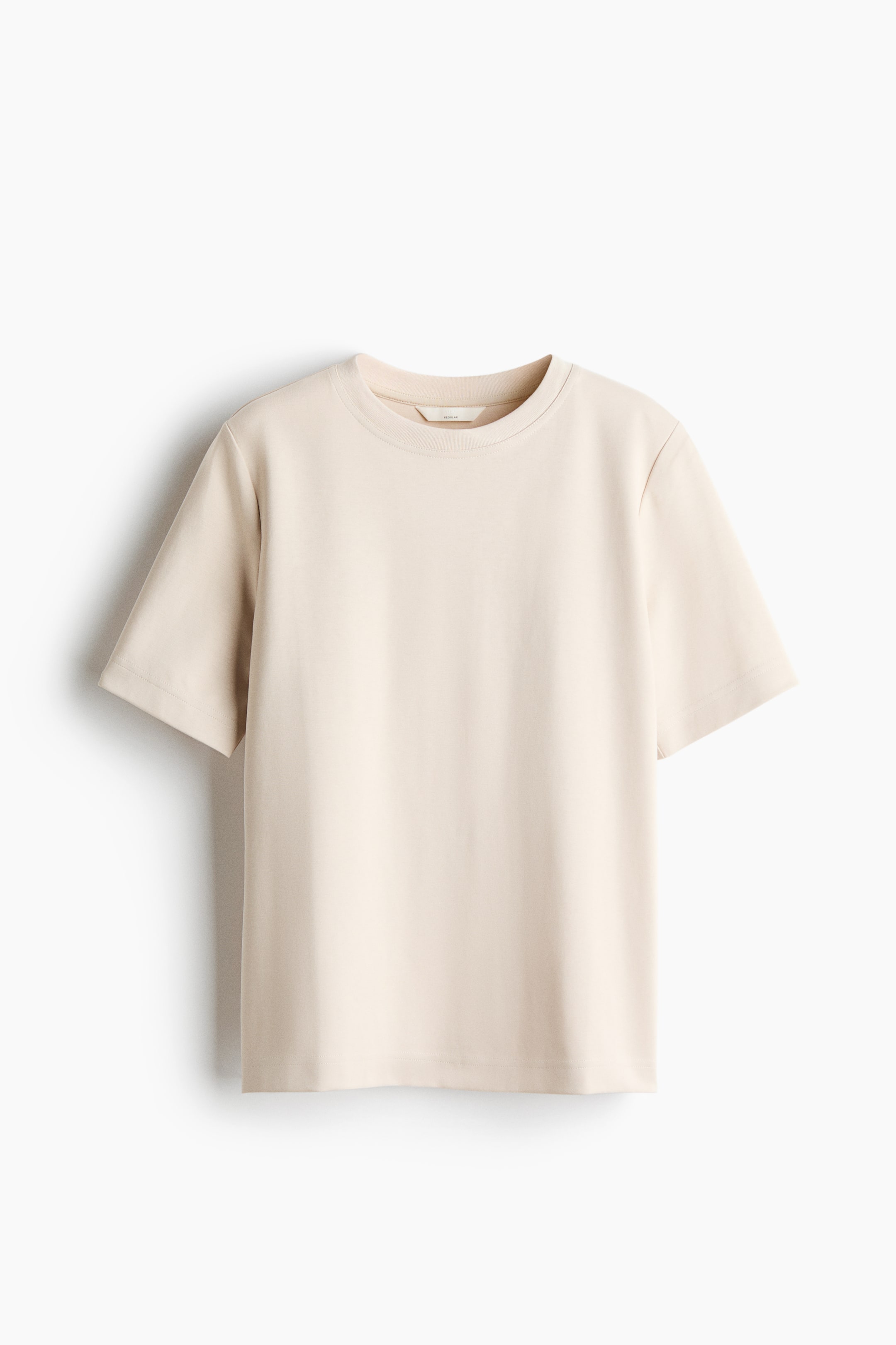 Grotere afbeelding bekijken: Een lichtbeige T-shirt met ronde hals is van voren gefotografeerd en toont de korte mouwen, geribbelde halslijn en rechte zoom.