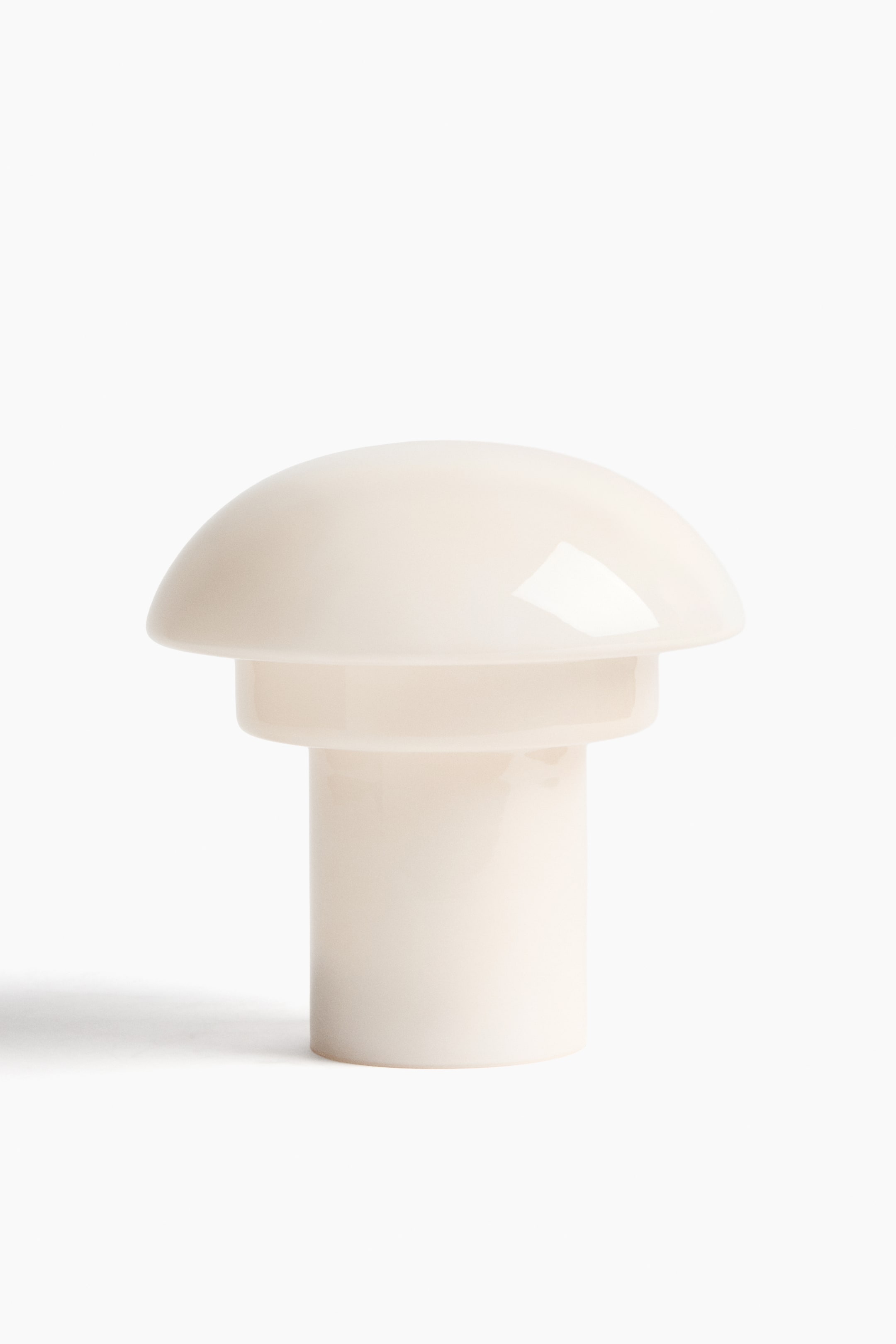 View larger image: A front-facing rechargeable table lamp is showcasing a cream-colored design, featuring a metal base that is topped with a dome-shaped coloured glass lampshade, concealing its internal structure.