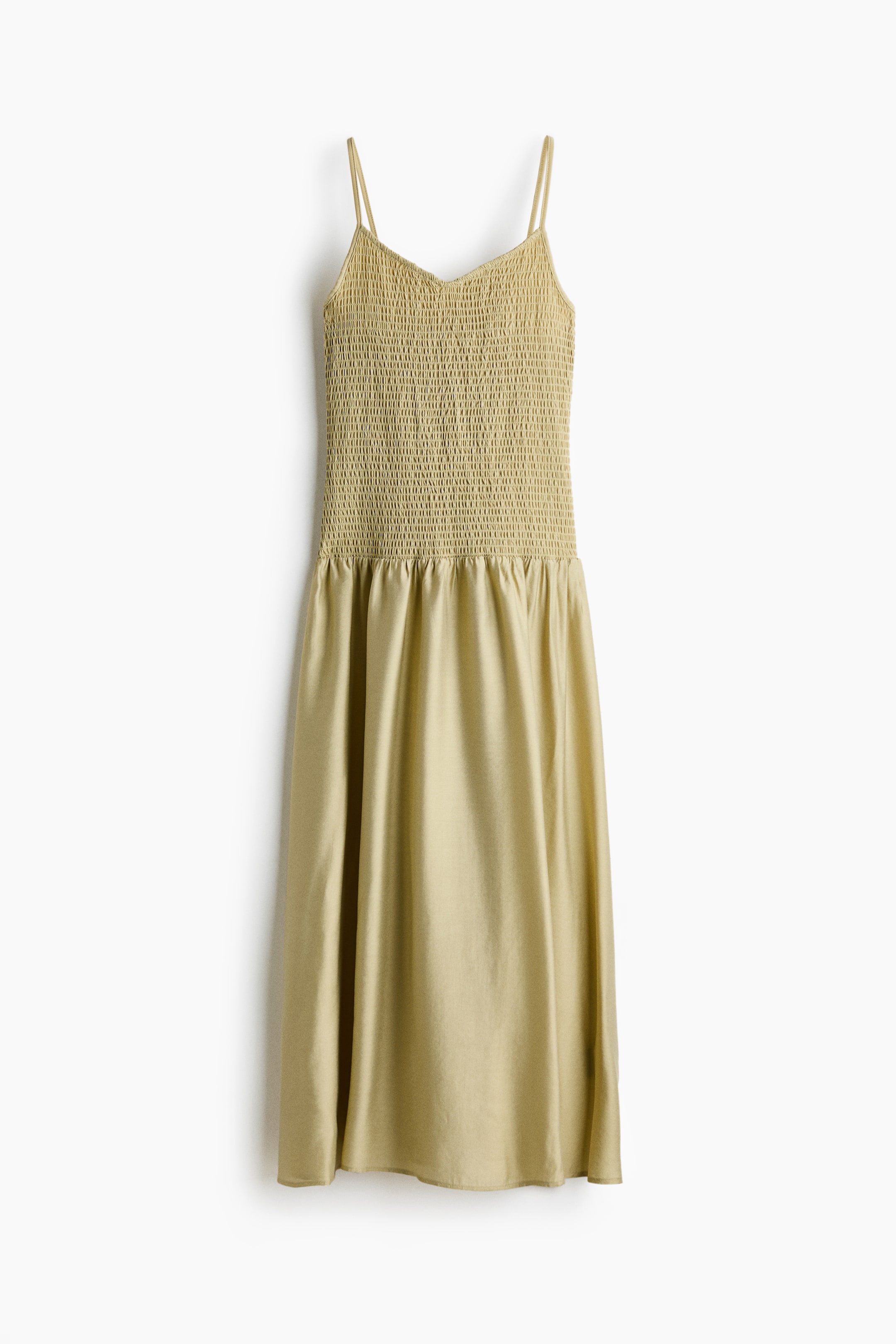 View larger image: Presenting a subtle olive green dress from the front, showcasing a smocked bodice with a V-neckline and slender spaghetti straps, transitioning into a gathered, flowing A-line skirt.