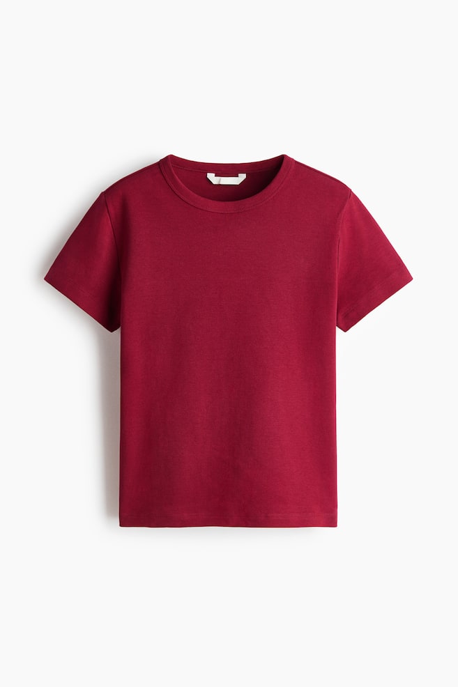 The deep red t-shirt is displaying a ribbed round neckline, short sleeves, and a straight-cut hem. - 1