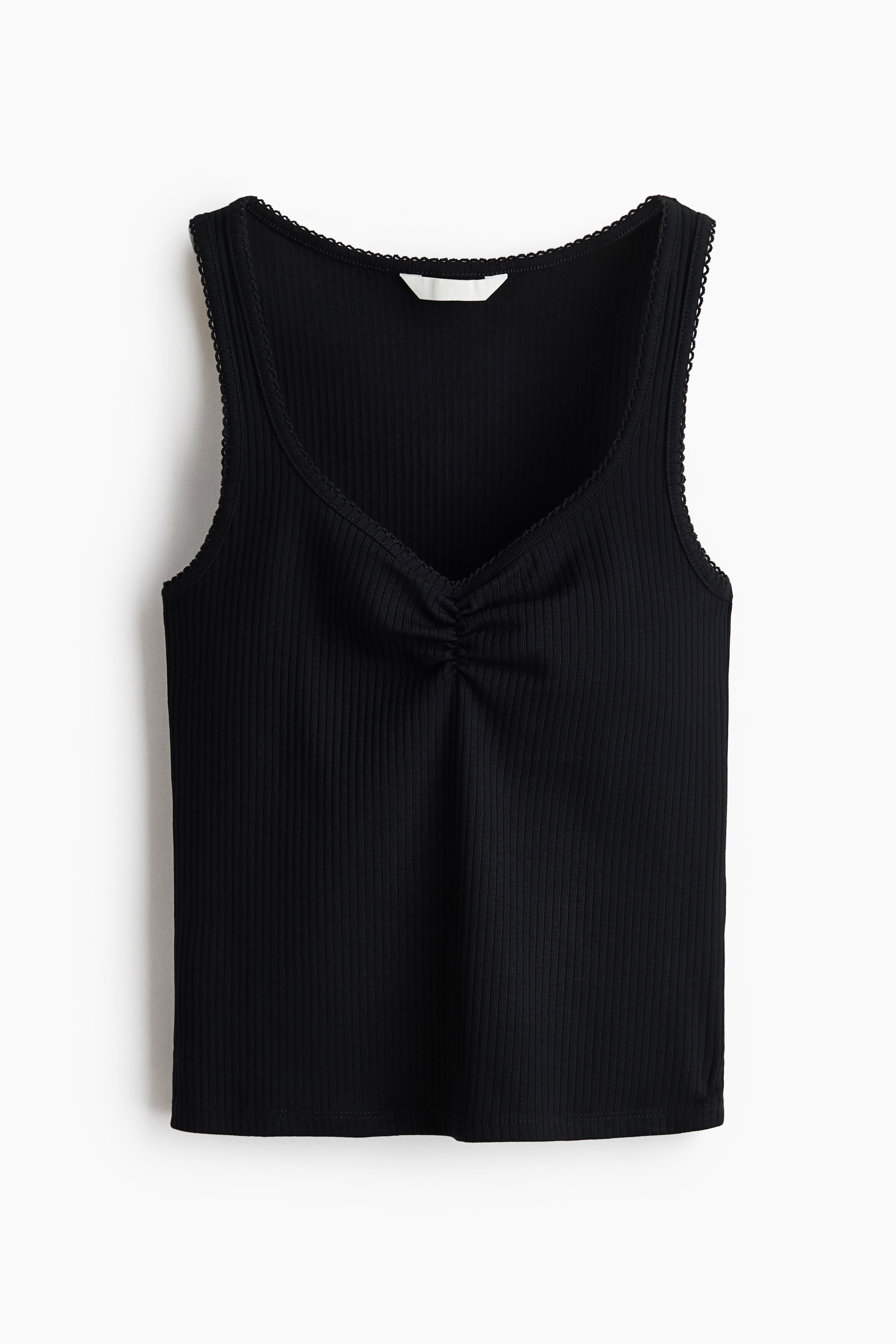 View larger image: A black ribbed tank top is displayed from the front, showcasing a V-neckline with a central ruched detail. It features delicate scalloped trim along the neckline and armholes, with a white label visible at the back of the neck.