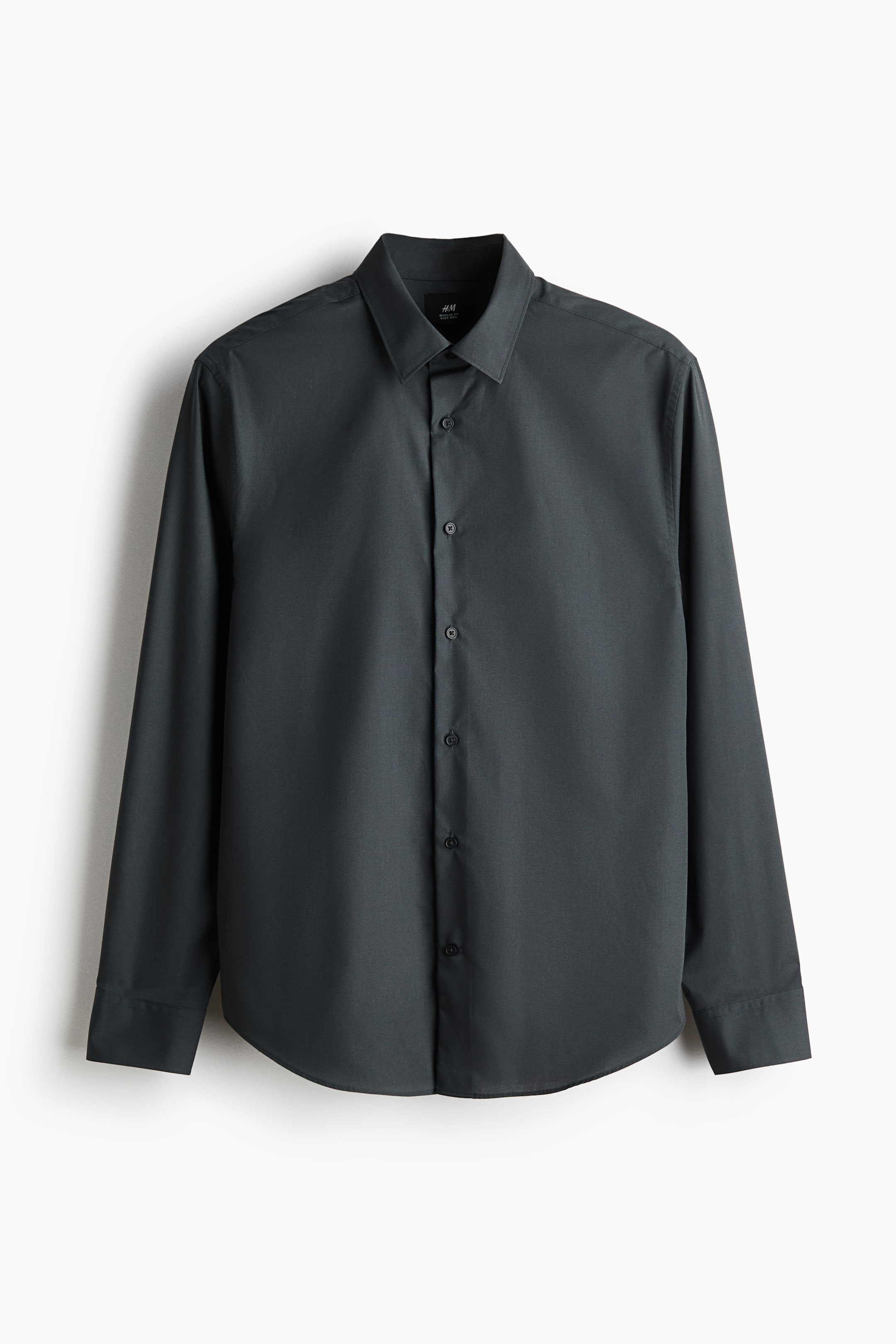 View larger image: The product is a dark gray shirt, featuring a turn-down collar and a front button closure with visible dark buttons. It presents long sleeves with buttoned cuffs and a rounded hem, all in smooth woven fabric.