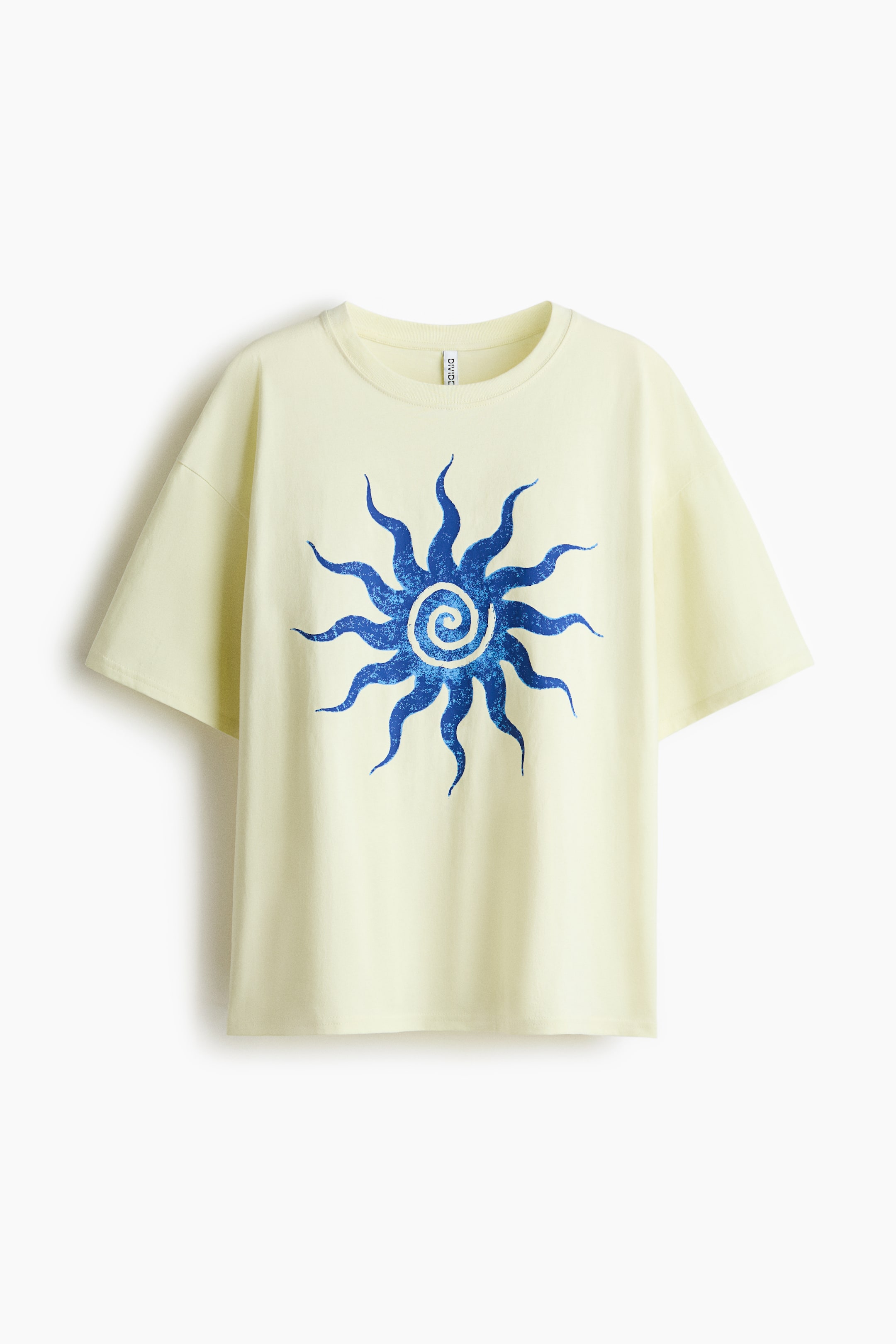 Ver imagen más grande: Una camiseta amarilla clara de gran tamaño en suave punto de algodón se ve desde el FRENTE, con un cuello redondo acanalado, hombros caídos y un dobladillo de corte recto. Un gran motivo de sol azul con rayos ondulados y una espiral central adorna el frente.