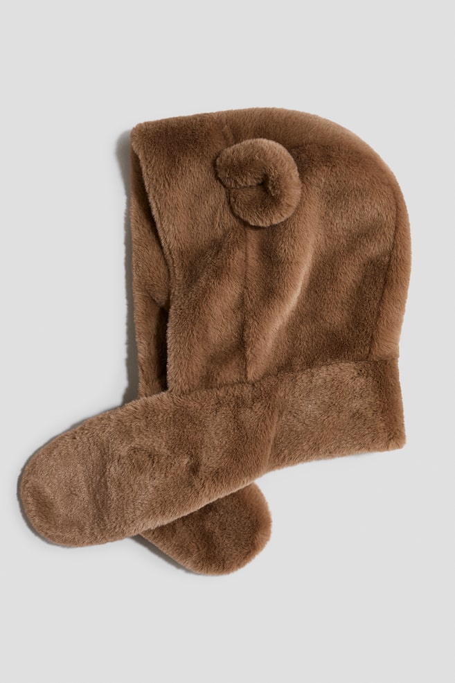 A brown faux fur hooded scarf is laid flat, showcasing its soft, plush texture and a small rounded ear on the side of the hood. The hood transitions into long, matching scarf extensions that cross over each other at the bottom. - 1