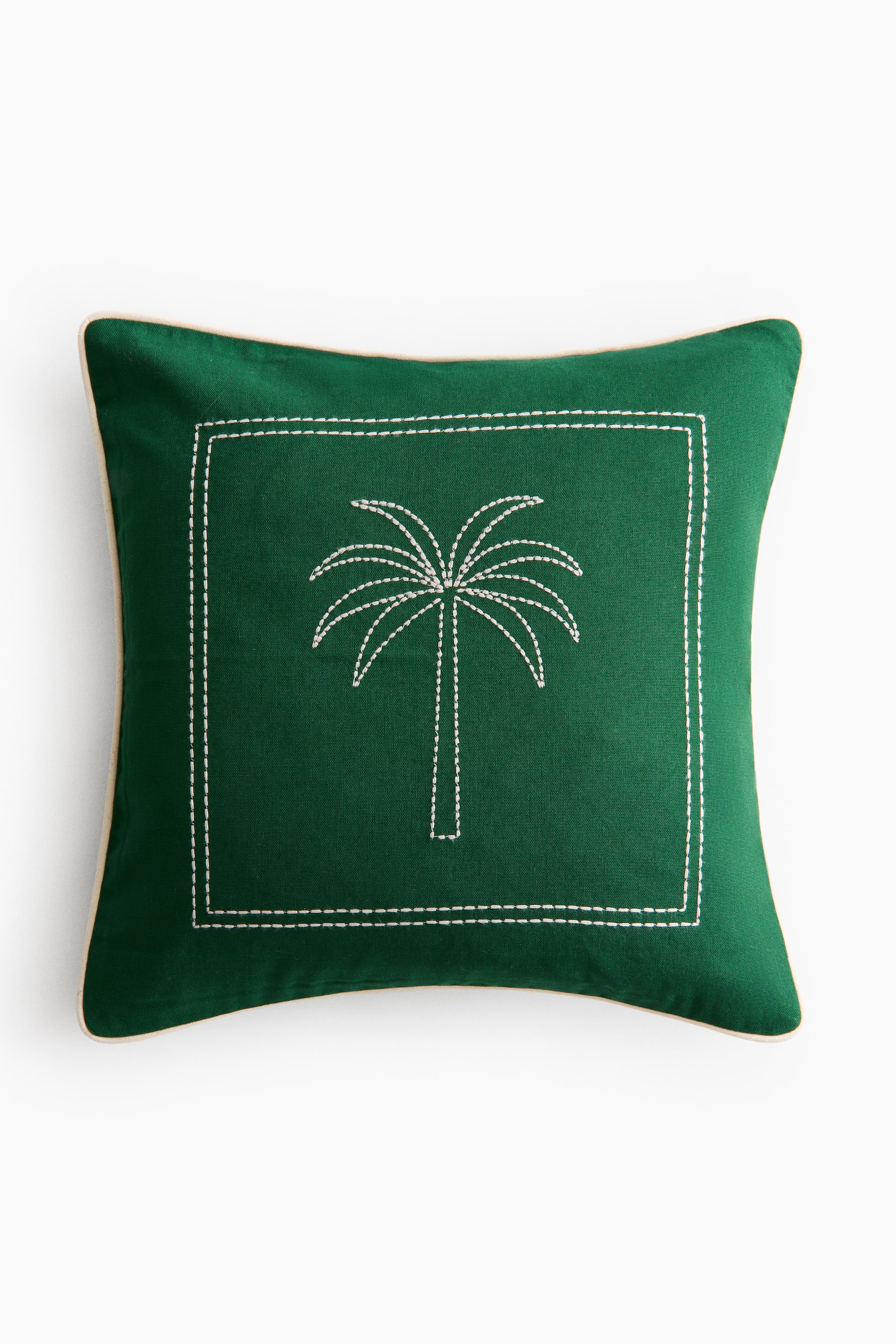 Voir une image plus grande: Un coussin carré vert foncé présente son DEVANT, mettant en vedette un motif de palmier blanc brodé centré à l'intérieur d'une bordure rectangulaire en pointillé blanc, et accentué par un passepoil blanc le long de ses bords.
