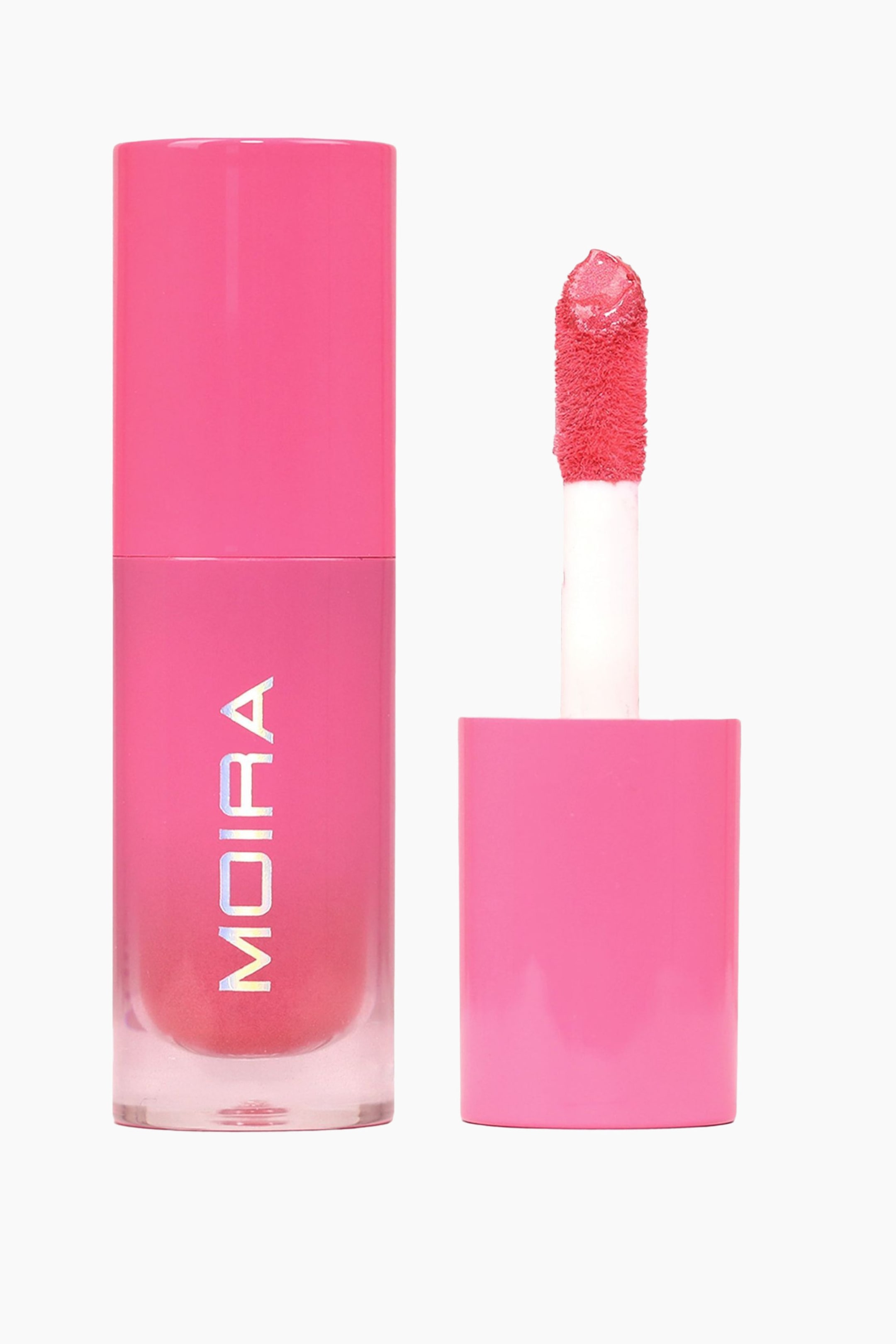 Vis større bilde: En lys rosa lipgloss blir presentert, med sin sylindriske tube og applikator vist separat. Tuben har en ugjennomsiktig rosa hette og en gjennomsiktig base som avslører den rosa glossvæsken og ordet 'MOIRA' trykt vertikalt, mens applikatorens flokkede, paddleformede tupp er mettet med den lyse rosa glossen.