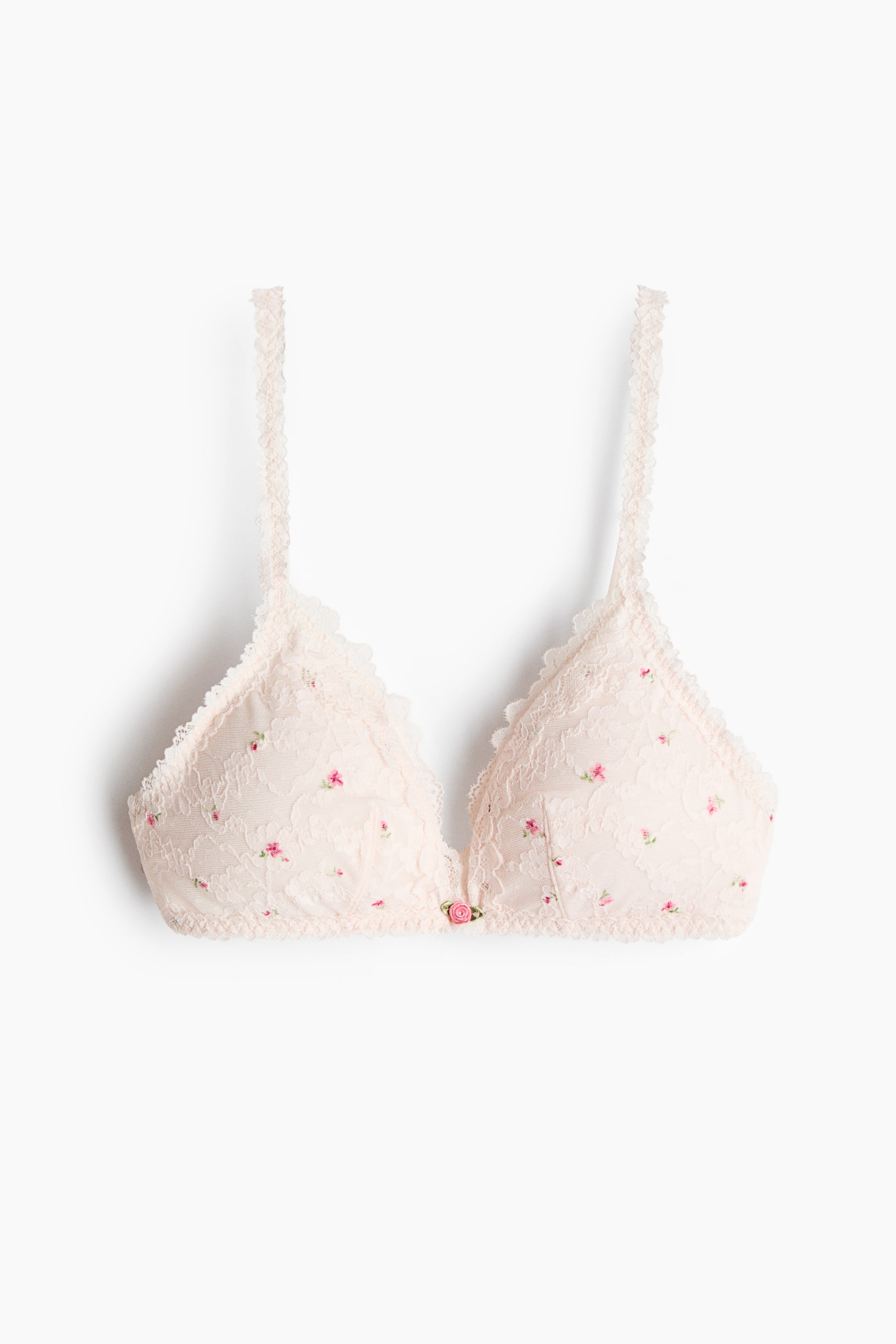 Voir une image plus grande: Un soutien-gorge souple en dentelle rose pâle à petit imprimé floral est présenté de face. Le soutien-gorge présente des bonnets triangulaires avec une bordure en dentelle festonnée, des bretelles en dentelle et un petit détail de bouton de rose rose au centre.