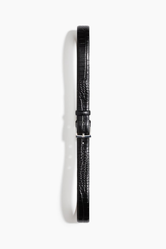 A black leather belt featuring a crocodile-embossed texture is extending vertically in a front view, fastened with a square silver-tone metal buckle and a matching leather keeper loop. - 1