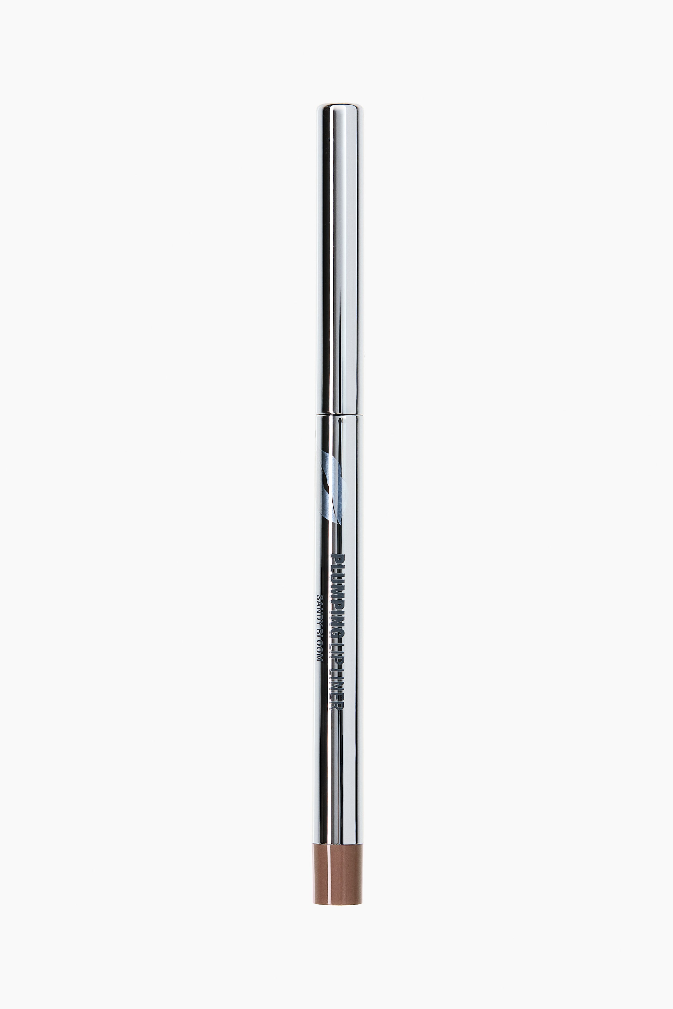 View larger image: A lip liner stands upright, showcasing a long, sleek, metallic silver casing. The words "PLUMPING LIP LINER" and "SANDY BLOOM" are displayed vertically along its side, with a brown product tip visible at the bottom.