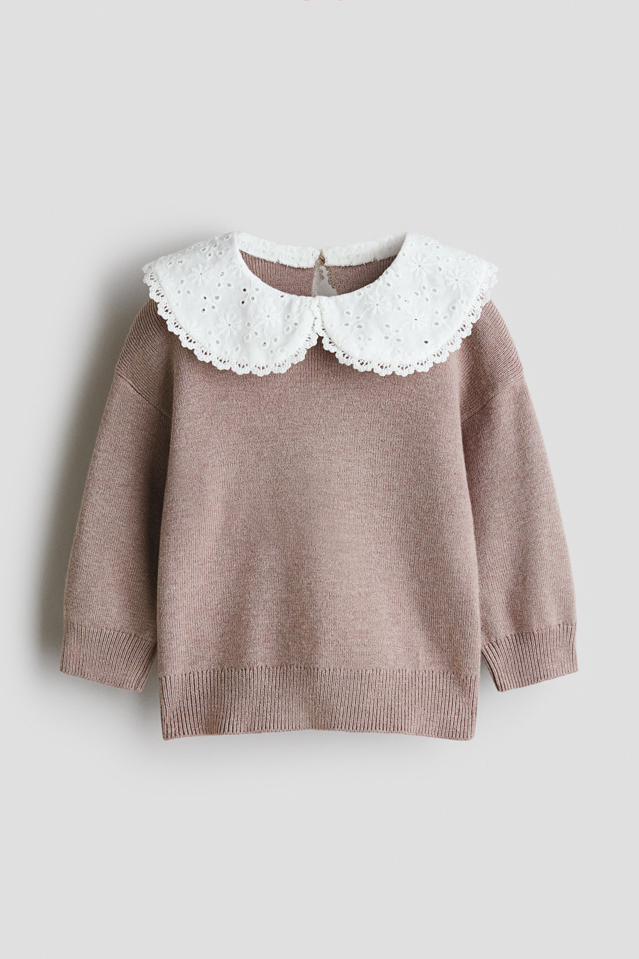 View larger image: A dusty pink, fine-knit sweater is shown from the front, featuring a contrasting white Peter Pan collar in a broderie anglaise weave with scalloped edges. The sweater has dropped shoulders, long sleeves with ribbed cuffs, and a ribbed hem.