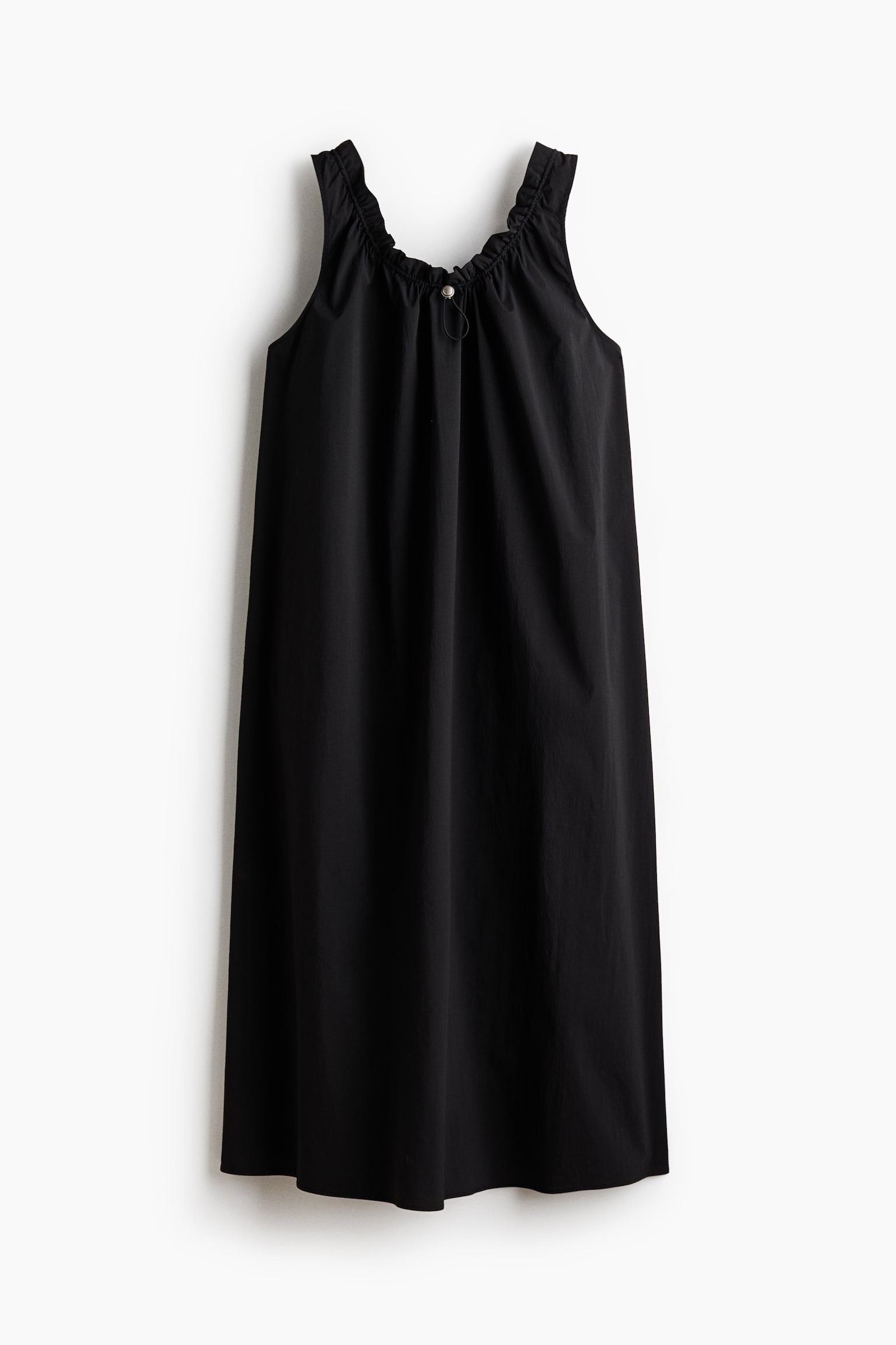 The black dress is shown front-facing, highlighting a gathered neckline with ruffled shoulder straps and a light-colored button closure at the center front. A thin tie detail is hanging below the button, while the dress flows downwards in a loose, straight silhouette. - 1