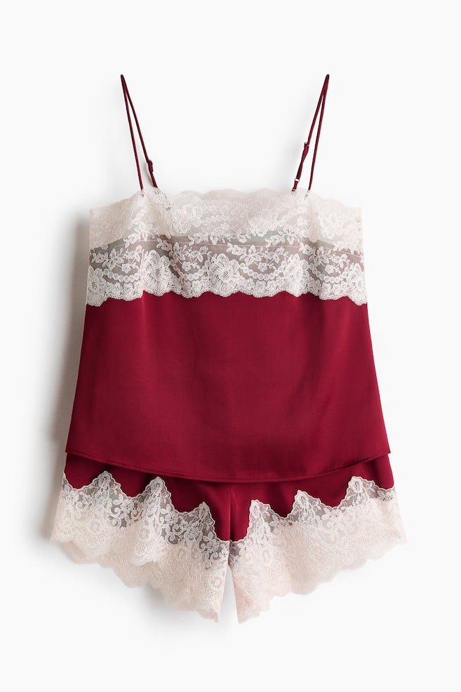 Acest set de pijama din douÄ piese, de culoare burgundy, este prezentat din faÈÄ Èi include un top tip camisole Èi Èorturi asortate. Topul tip camisole evidenÈiazÄ bretele subÈiri, reglabile, tip spaghetti, Èi o bandÄ latÄ de dantelÄ floralÄ Ã®n nuanÈÄ crem, dispusÄ de-a lungul pÄrÈii superioare a pieptului, Ã®n timp ce Èorturile prezintÄ un tiv asortat din dantelÄ cu margini festonate la terminaÈii. - 1