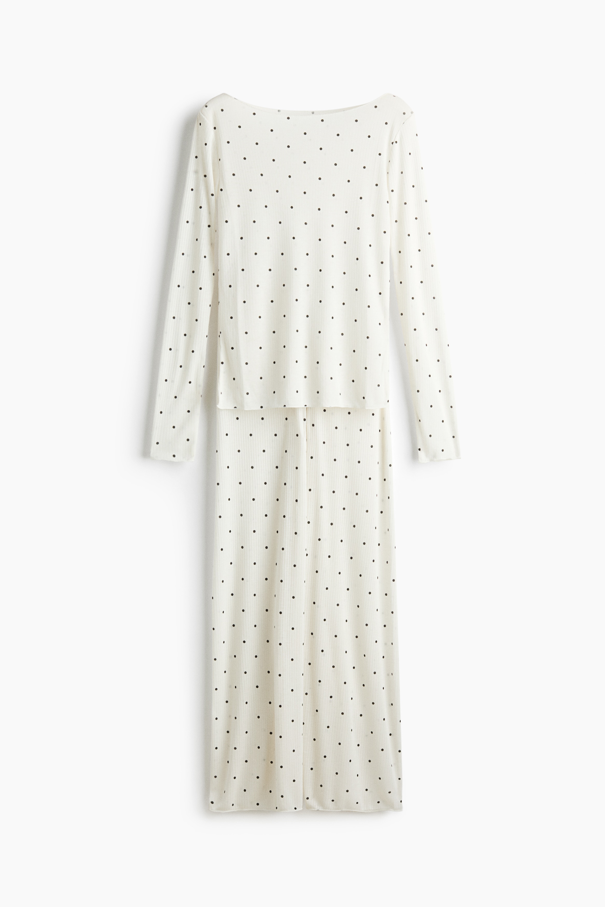Das Model trÃ¤gt ein Pyjama-Set in Off-White aus gerippter JerseyqualitÃ¤t mit schwarzem Polka-Dot-Muster. Das Set besteht aus einem figurbetonten, langÃ¤rmeligen Oberteil mit Boot-Ausschnitt und einer dazu passenden Hose mit weitem Bein und elastischem Tunnelzugbund.