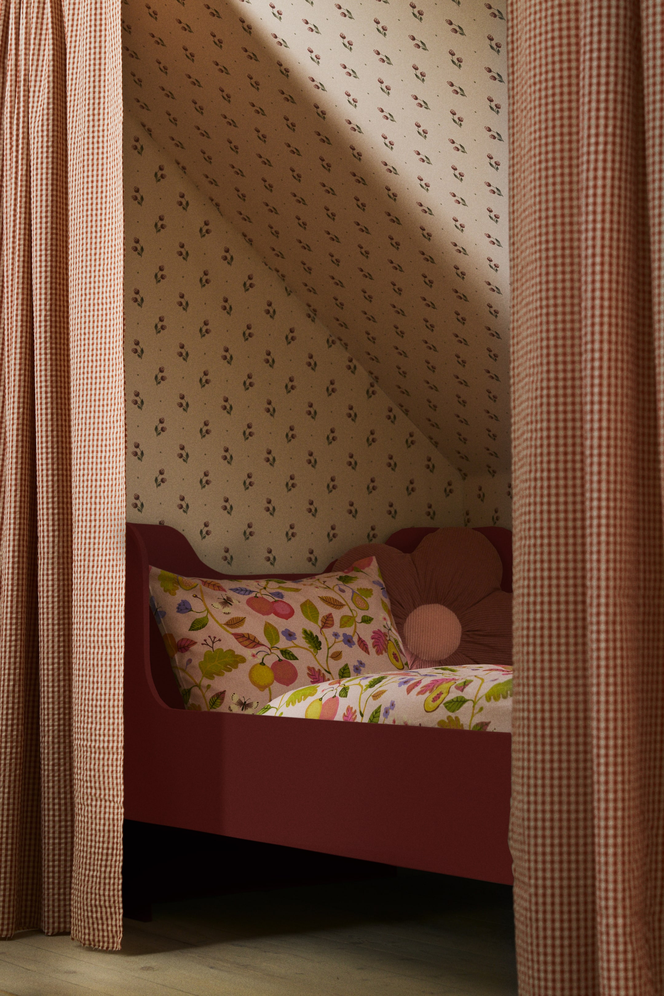 Nagyobb kép megtekintése: Egy paplanhuzat garnitúra színes, gyümölcsöket, leveleket és apró rovarokat ábrázoló, teljes felületű mintával rendelkezik, világos háttéren. A paplanhuzat az ágyat borítja, és a hozzáillő párnahuzat az ágy fejénél helyezkedik el.