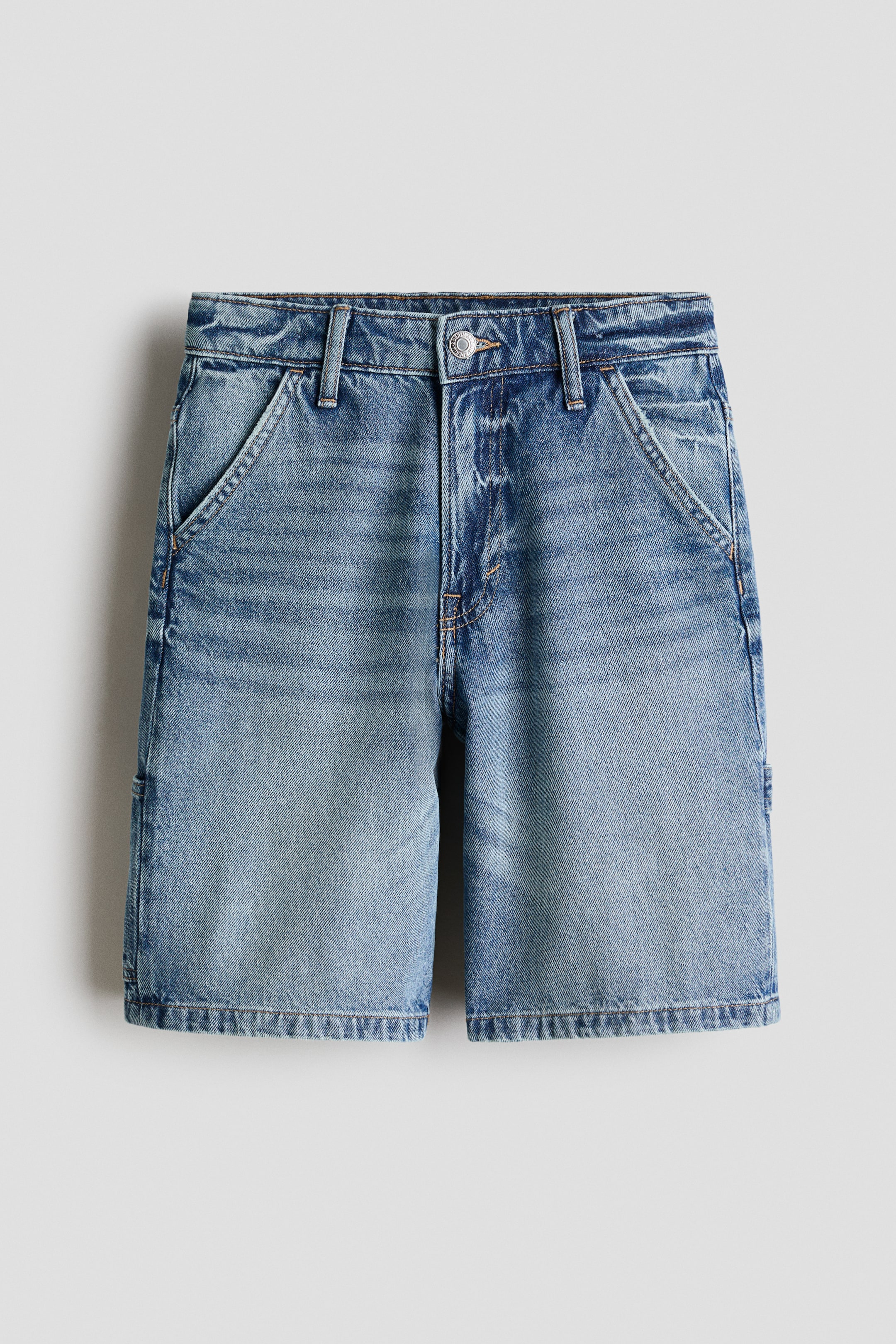 Größeres Bild ansehen: Diese knielangen, locker sitzenden Shorts aus hellblauem Baumwoll-Denim verfügen über eine Vorderansicht mit Reißverschluss, Knopfverschluss, diagonalen Vordertaschen und einer Hammerschlaufe auf der linken Seite.