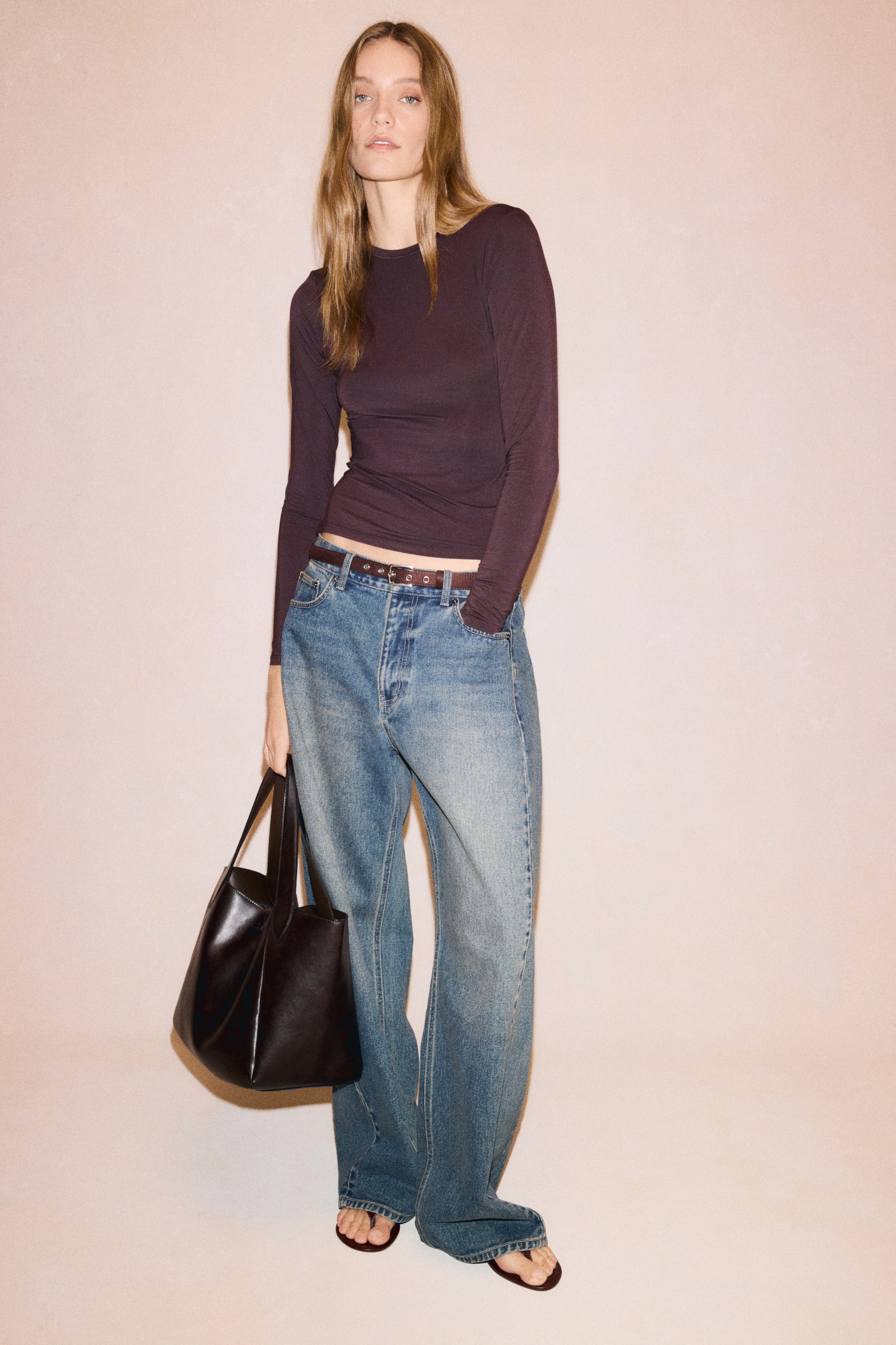 View larger image: A dark plum fitted top features a round neckline, long sleeves, and a straight-cut hem in the front view. The top is subtly sheer and body-hugging.
