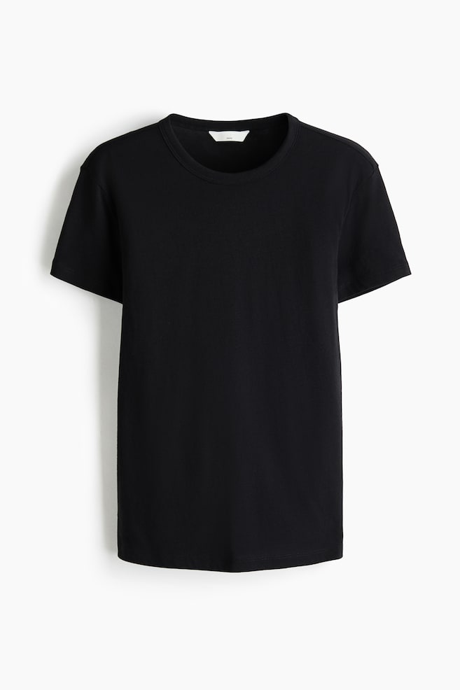 Een zwart T-shirt wordt van voren getoond, met een ronde hals, korte mouwen en een klein wit label zichtbaar aan de binnenkant van de achterste kraag. - 1