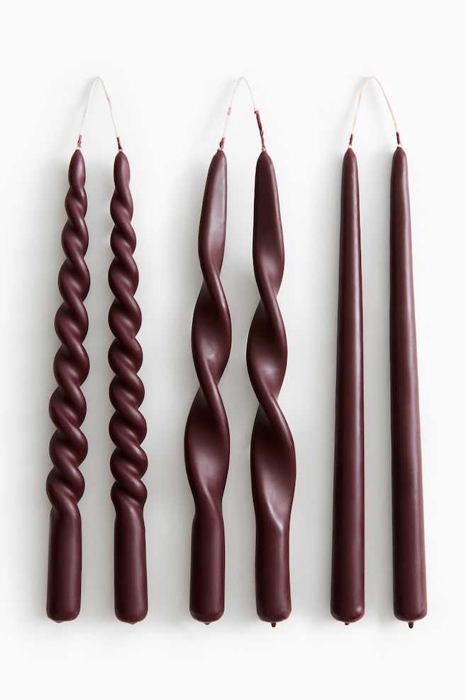 Trois paires de bougies effilées bordeaux foncé sont disposées de face, chaque paire étant reliée en haut par une mèche claire continue. Les bougies présentent trois motifs distincts : une spirale serrée à gauche, une spirale lâche au centre et une forme effilée classique et lisse à droite. - 1
