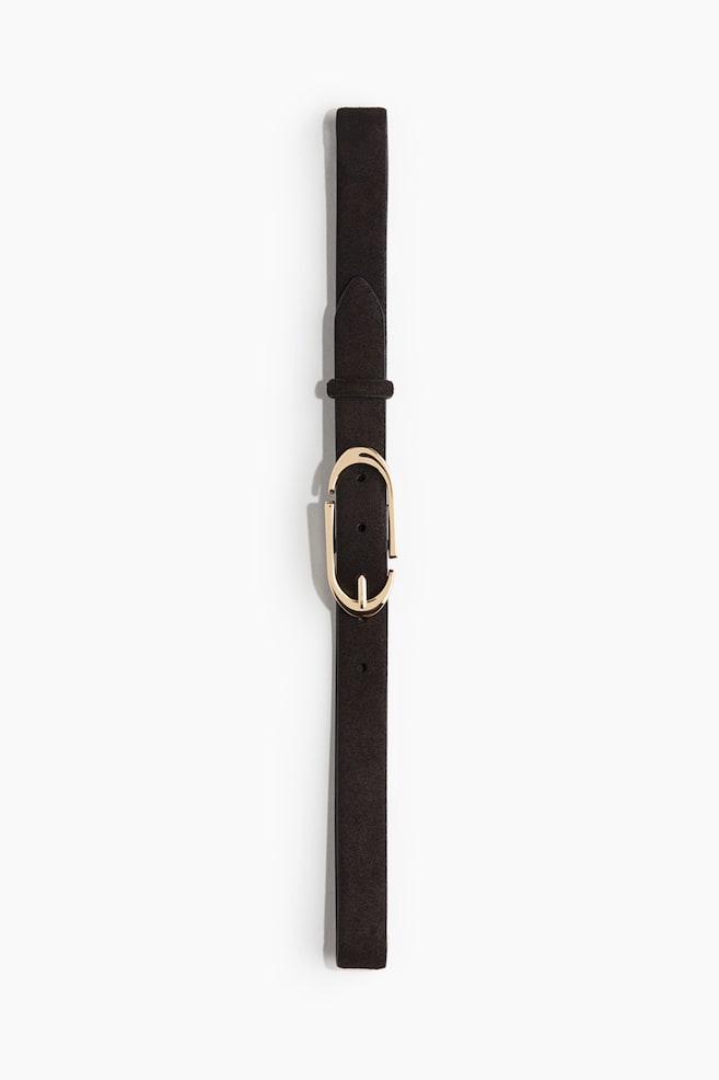 Une ceinture marron foncé est posée à plat, montrant son devant. Elle présente une boucle ovale allongée de couleur dorée avec un design ouvert et une épingle intégrée, et la sangle semble avoir une finition mate ou semblable à du daim. - 1