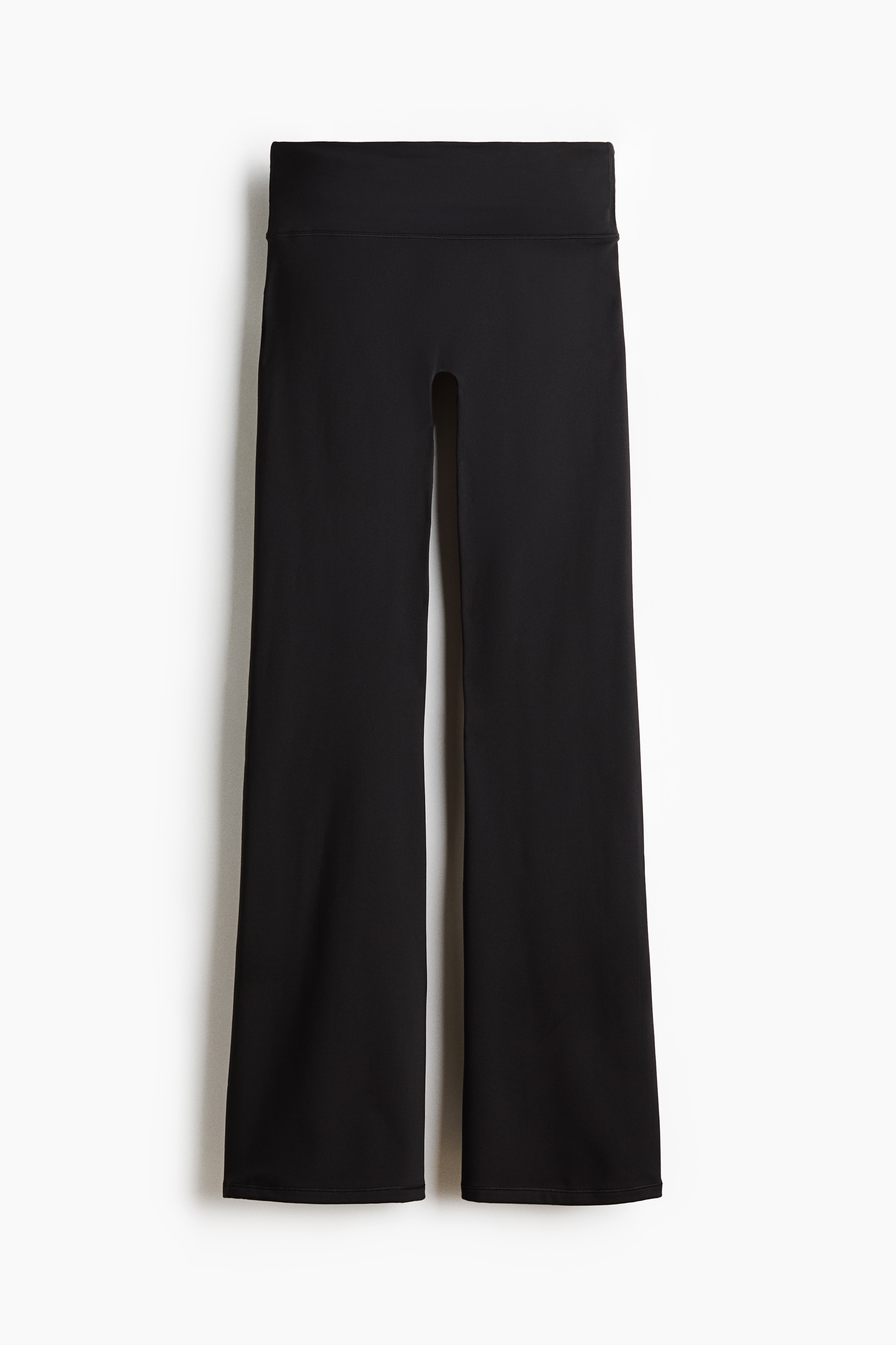 La modelo lleva una sudadera con capucha de forro polar texturizado en gris oscuro, con cremallera frontal, capucha y bajo con cordÃ³n ajustable. La prenda exterior se combina con pantalones negros acampanados y zapatillas negras.